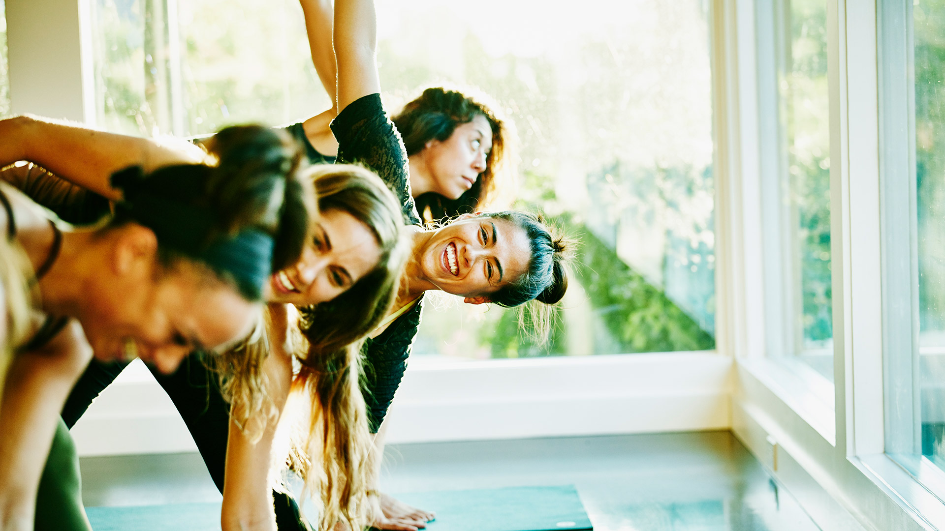 Smiling woman laughing with friends during yoga class in studio