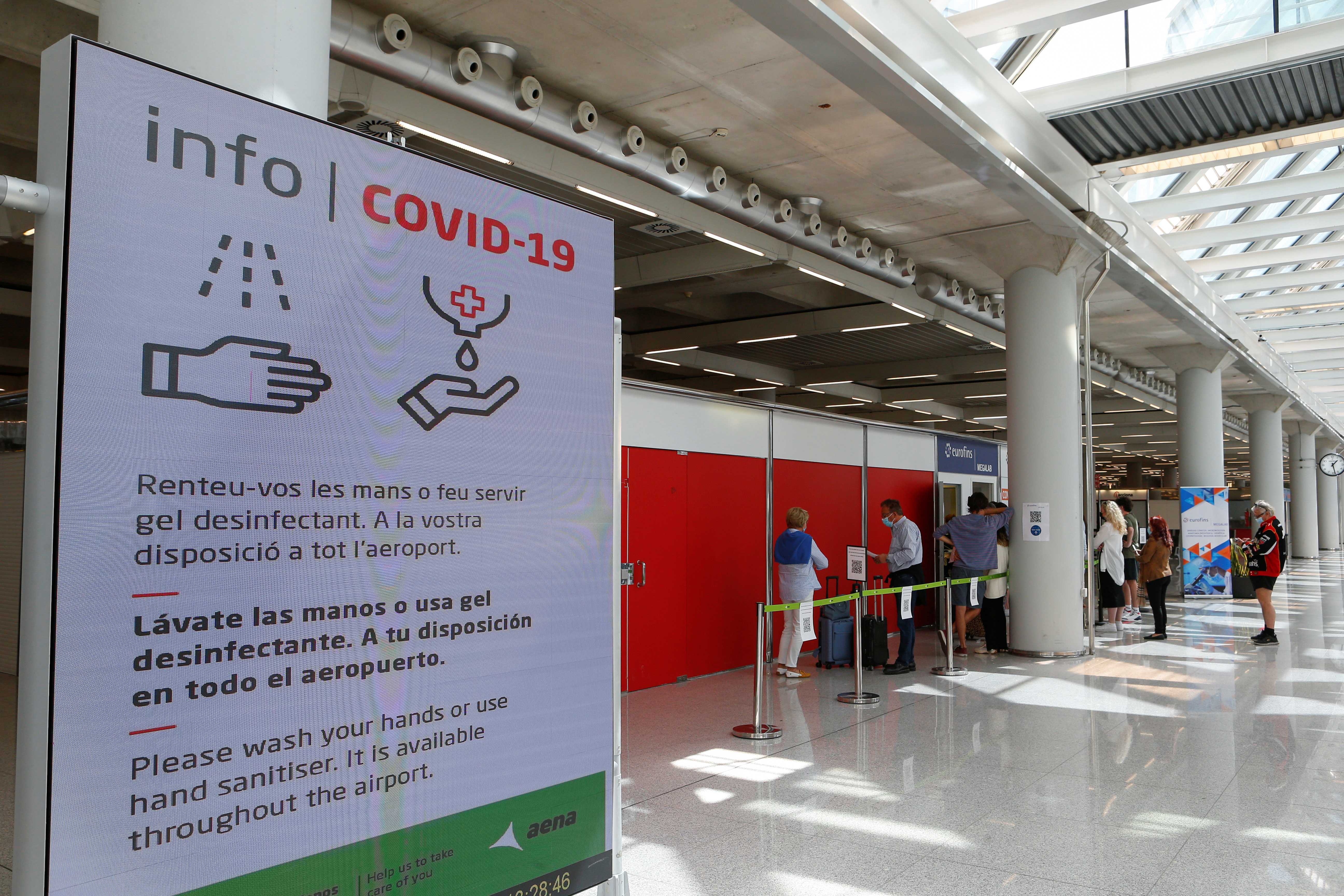 Personas hacen cola frente a un sitio de testeo de COVID-19 en el aeropuerto de Son Sant Joan en Palma de Mallorca, España, 30 de marzo de 2021. (REUTERS / Enrique Calvo)