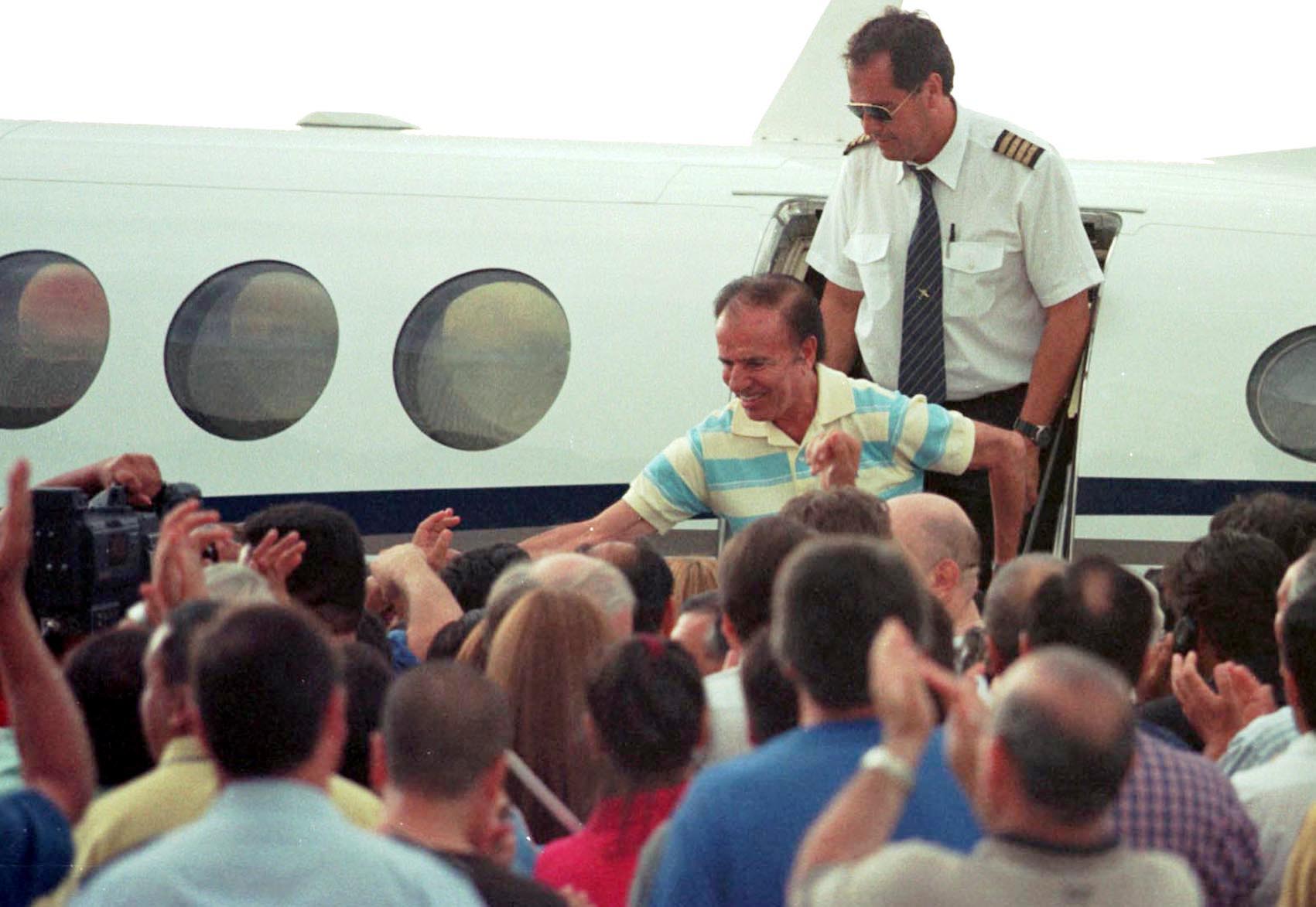 El ex presidente Carlos Menem, recibido por una multitud al arribar a su provincia luego de haber quedado en libertad
