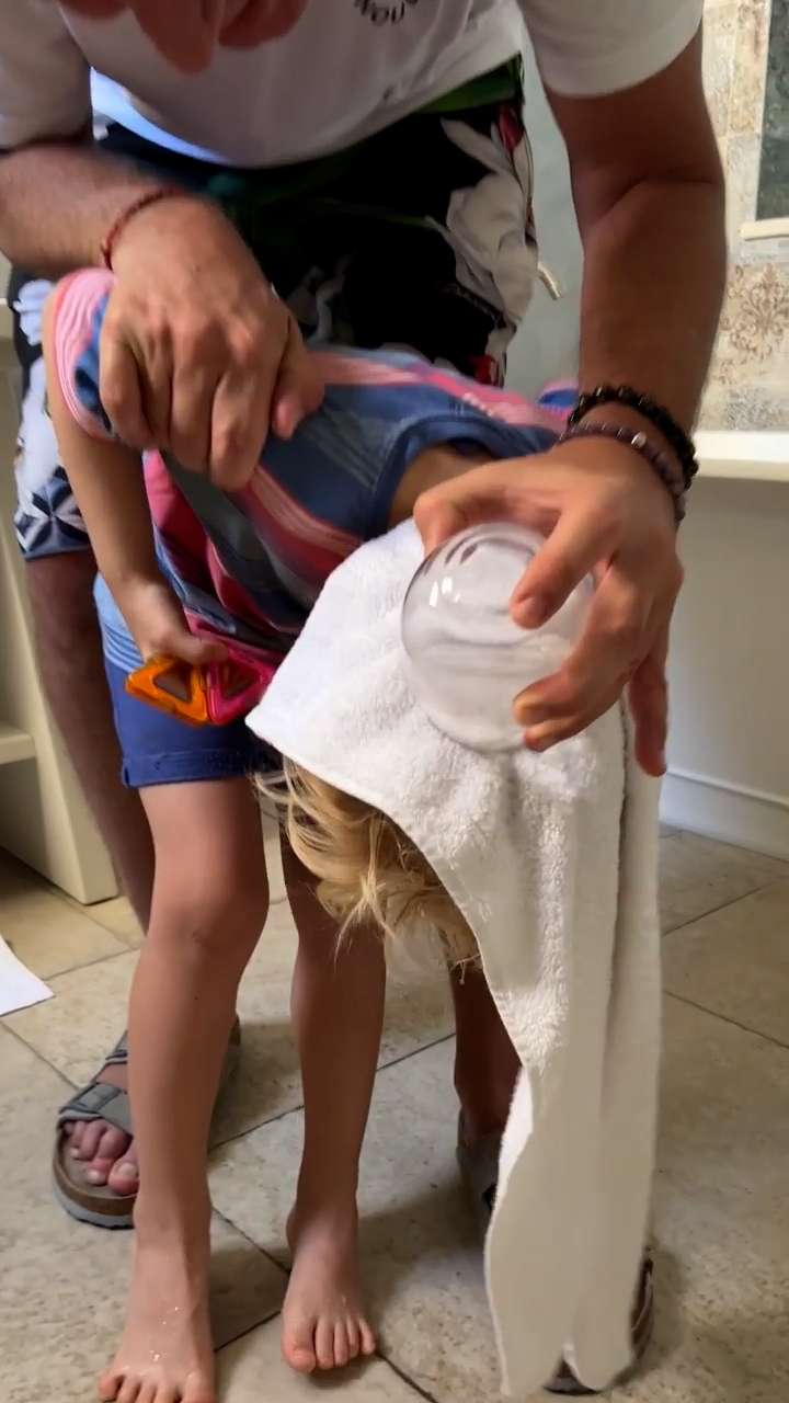 Secondo tentativo: Marley usa un asciugamano per evitare che i capelli di Mirko si bagnino (Foto: Instagram)