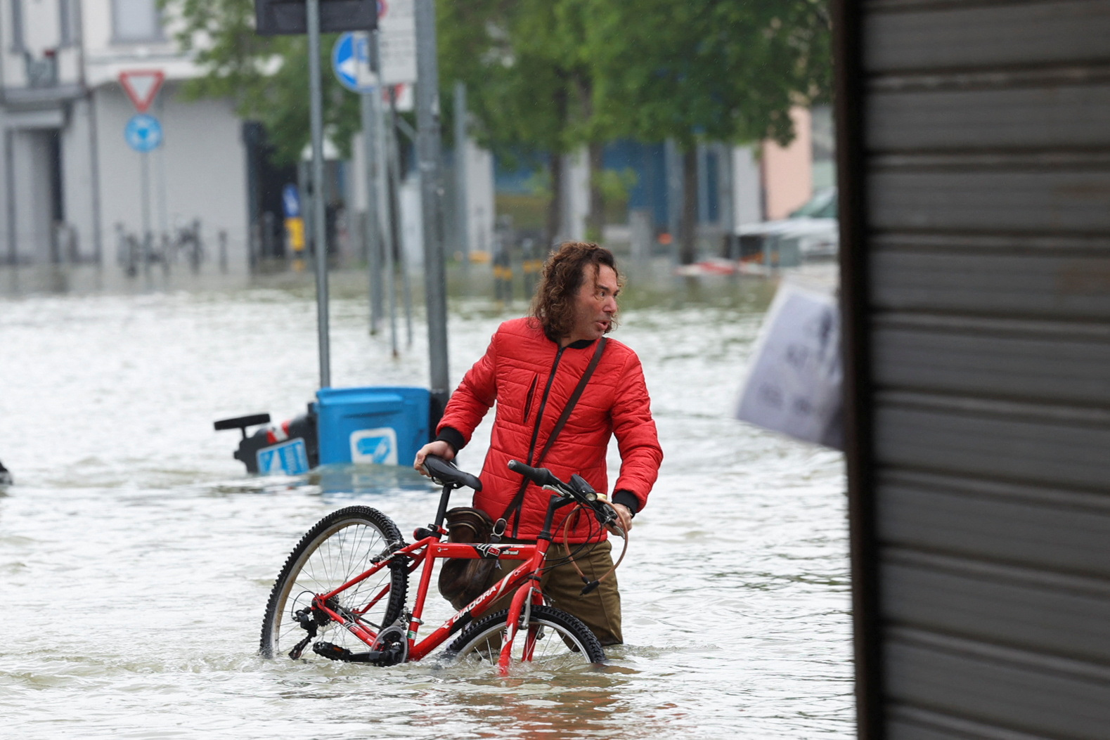 Un hombre vadea con su bicicleta a través de las inundaciones en Lugo  (REUTERS/Claudia Greco)