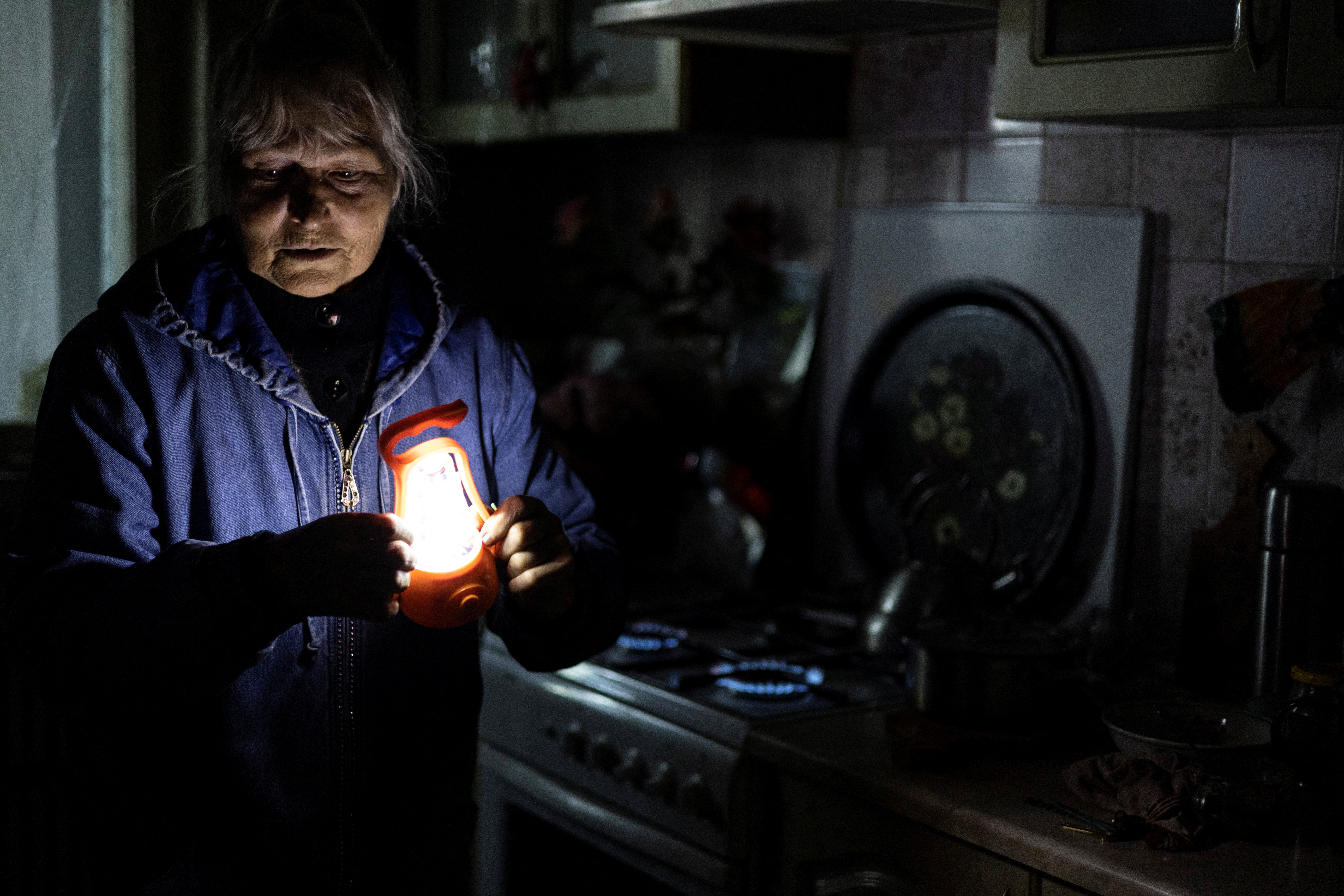 Olga Kobzar stands in her kitchen as she shows how she heats her house by gas stove cooktop, as Russia's attack on Ukraine continues, in her apartment in Saltivka neighbourhood of Kharkiv, Ukraine, September 22, 2022. REUTERS/Umit Bektas