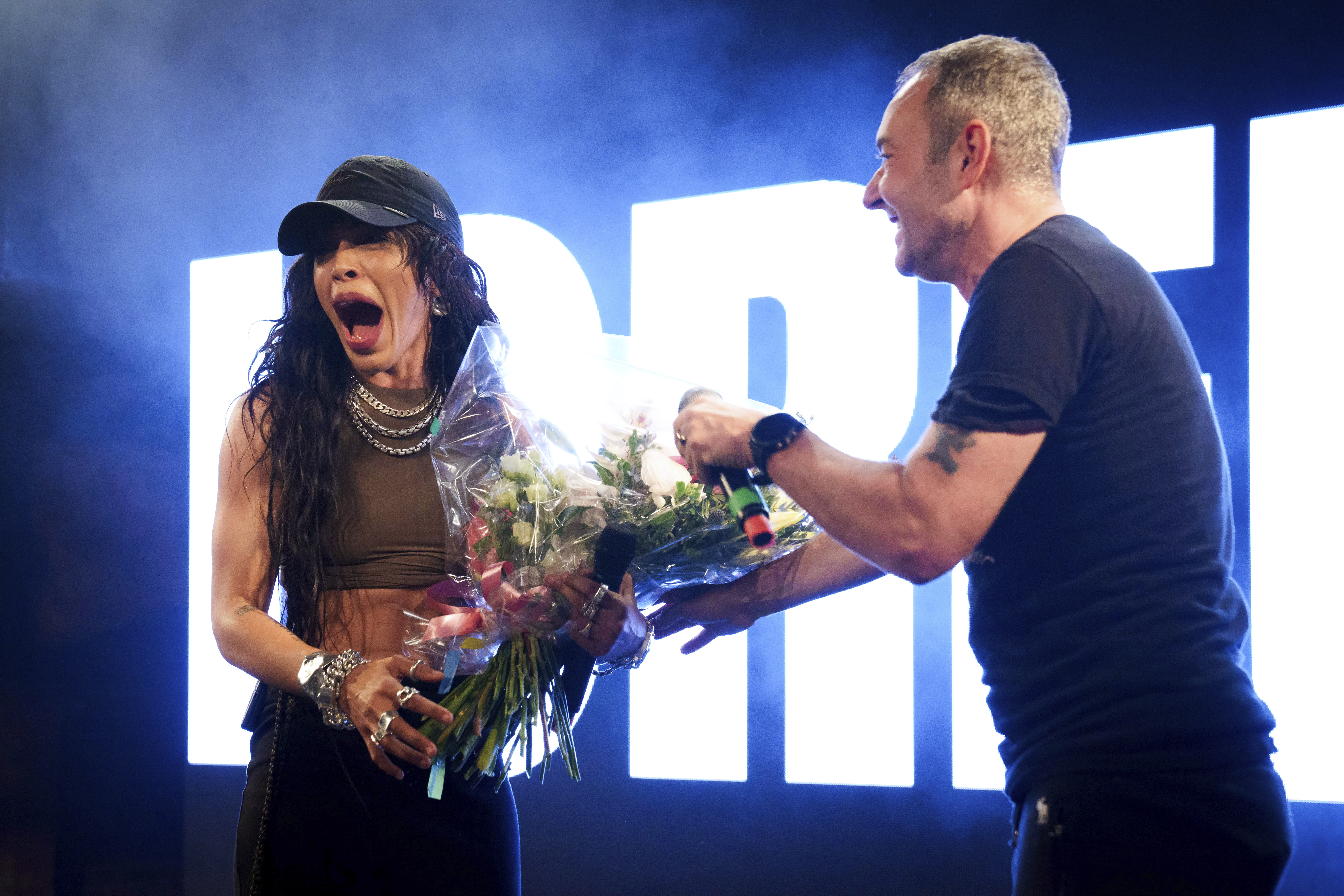 Loreen, left, receives a bouquet of roses from Jeremy Joseph onstage at Heaven Nightclub in London on Tuesday, April 18, 2023. (Scott Garfitt/Invision/AP)