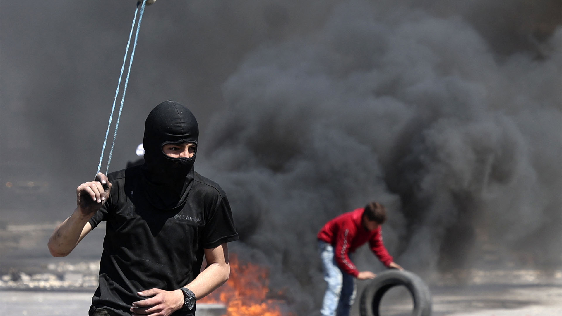 Un palestino en primer plano mientras los incidentes continuaban detrás suyo (JAAFAR ASHTIYEH / AFP)