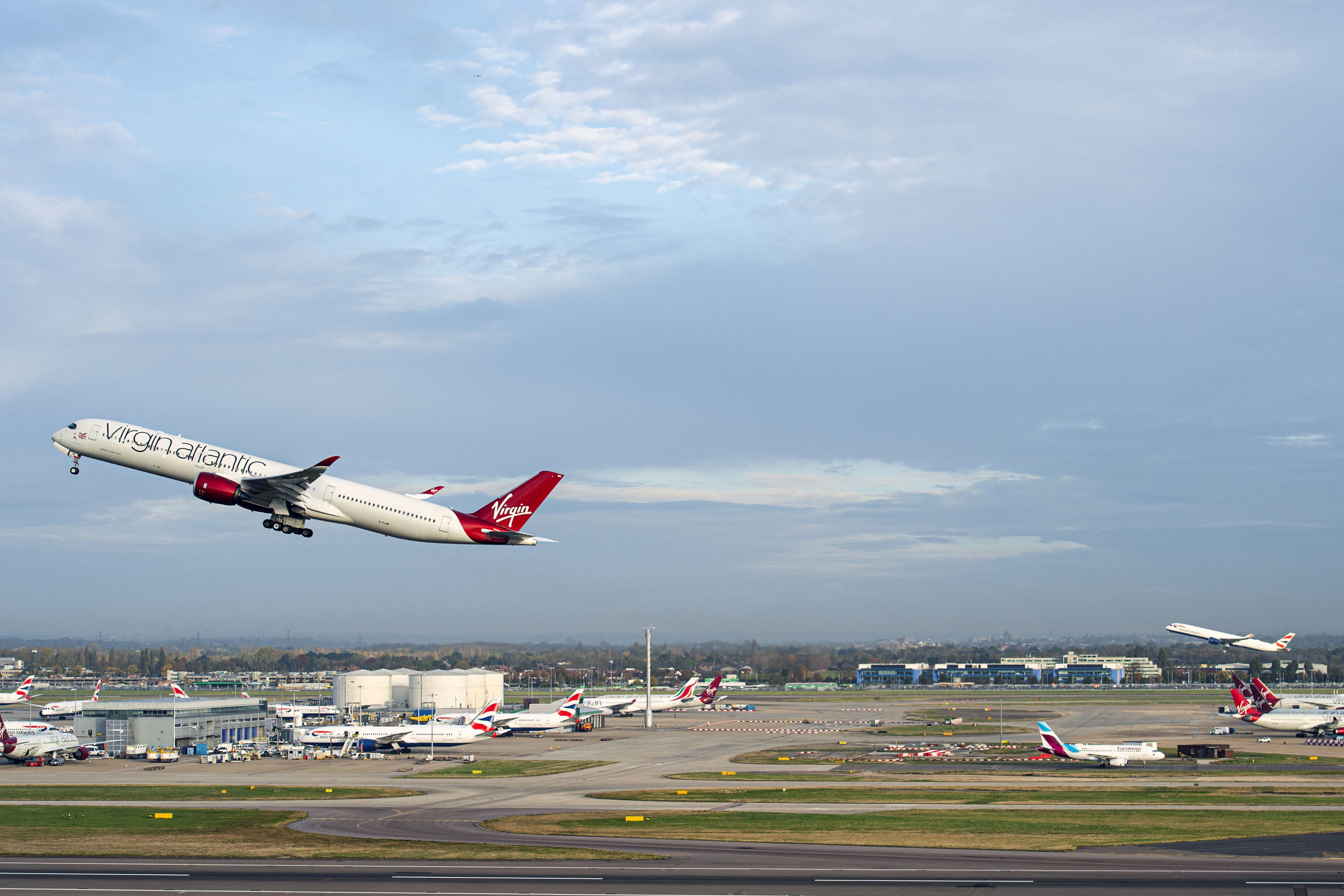 El vuelo VS3 de Virgin Atlantic, delantero, y el vuelo BA001 de British Airways realizan una salida sincronizada en pistas paralelas en el Aeropuerto Heathrow de Londres, el lunes 8 de noviembre de 2021 rumbo al aeropuerto JFK de Nueva York para celebrar la reapertura del corredor de viajes transatlántico. (Anthony Upton/PA via AP)
