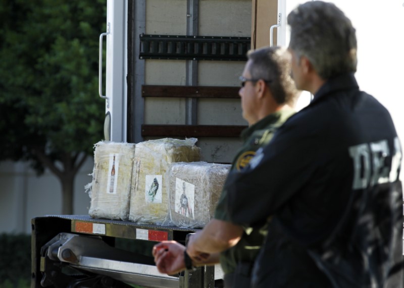 FOTO DE ARCHIVO-Un agente de la DEA y un oficial de la patrulla fronteriza se encuentran junto a algunas de las más de 14 toneladas de marihuana incautadas después de descubrir un importante túnel transfronterizo de drogas en Otay Mesa, California November 16, 2011. REUTERS/Mike Blake