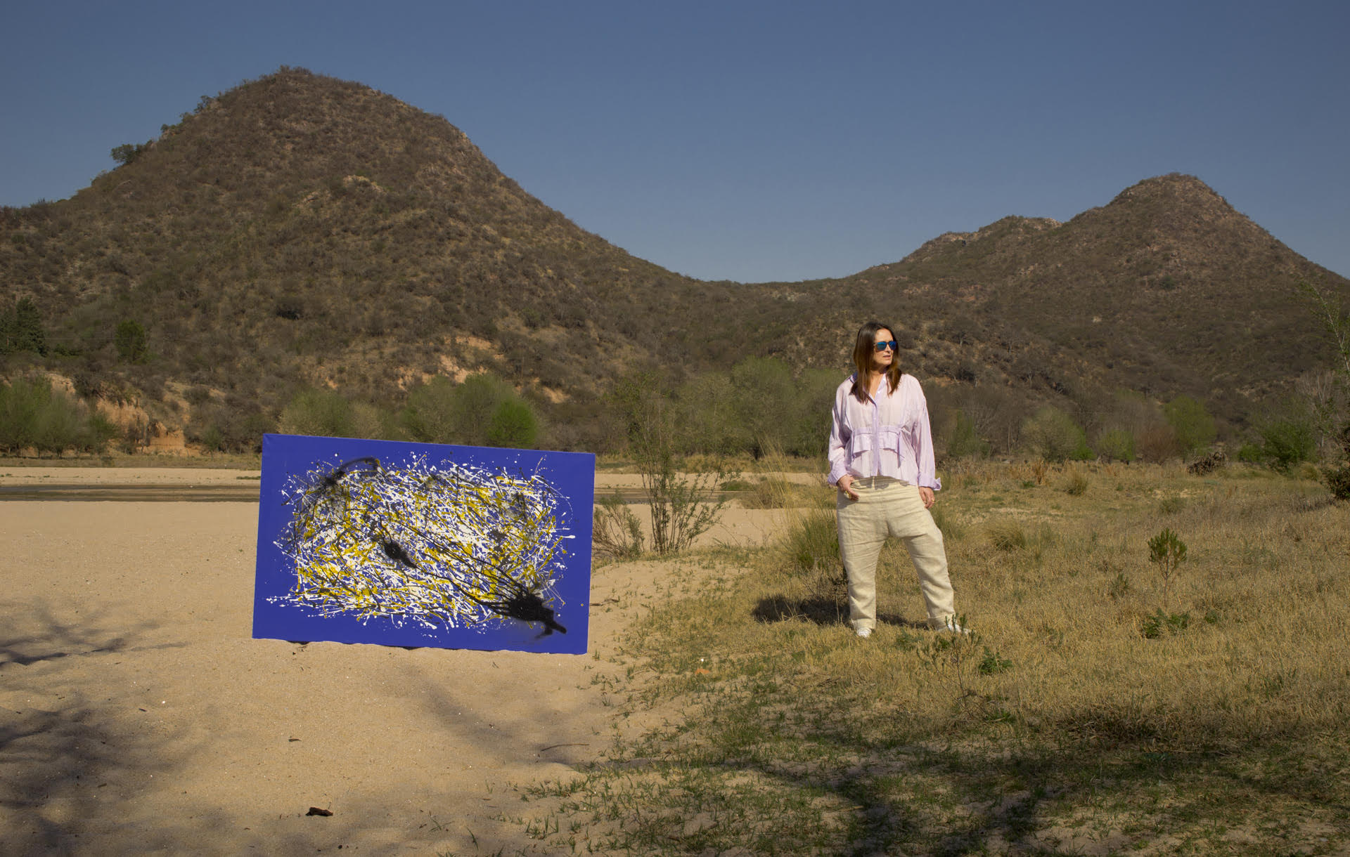 Silvana Suárez posa en las sierras cordobesas junto a una de sus pinturas (Andrei Durán)