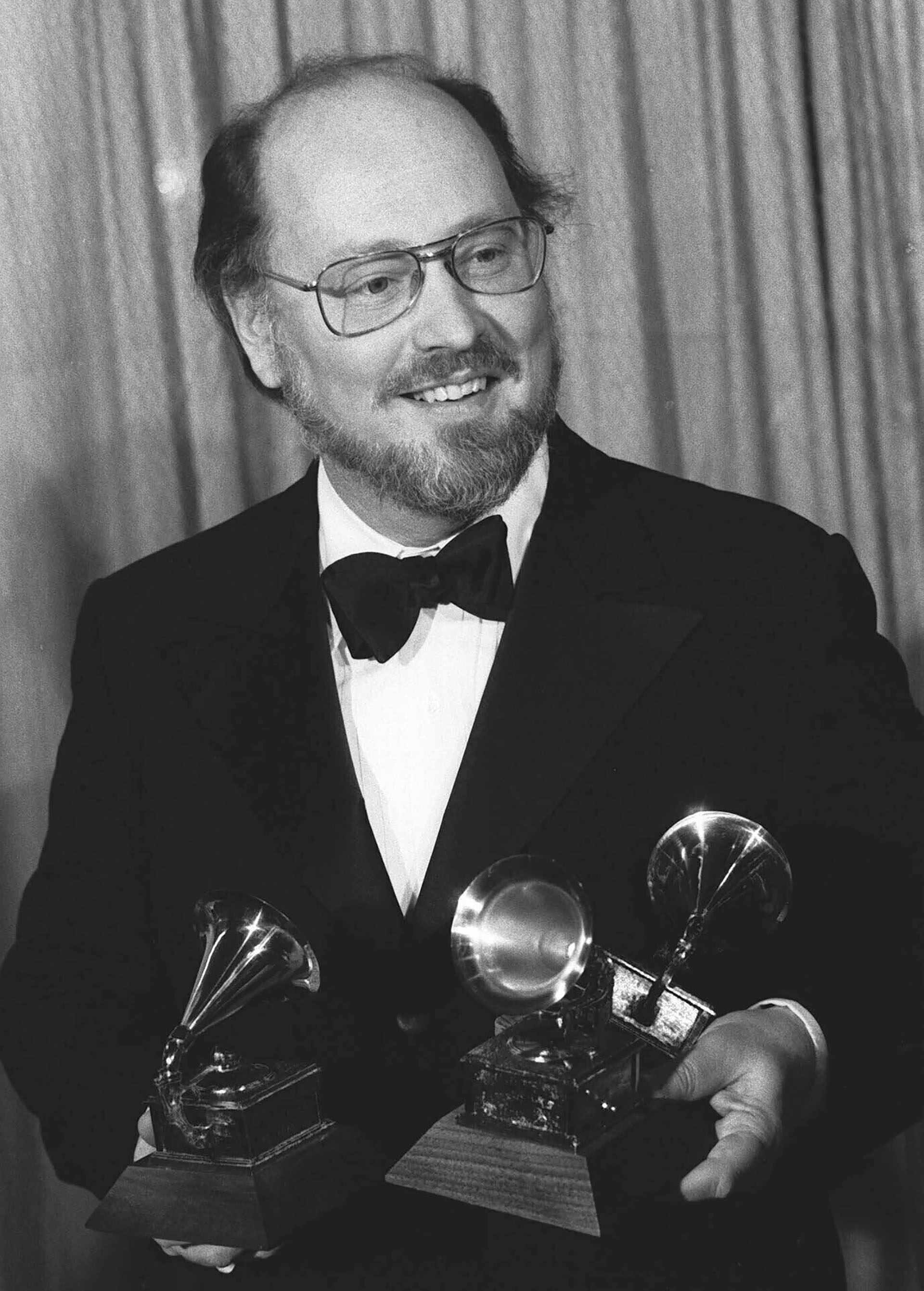 El músico John Williams sostiene tres premios Grammy que ganó por su trabajo para "Star Wars", a la mejor banda sonora original, mejor composición instrumental y mejor grabación pop instrumental, el 23 de febrero de 1978 en Los Ángeles. (Foto AP, archivo)