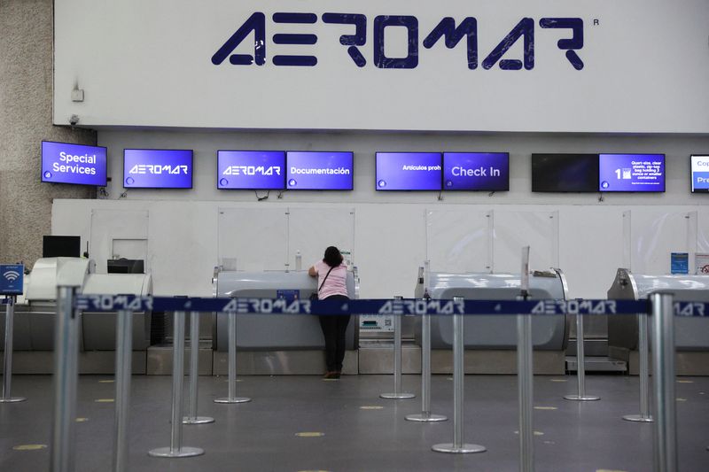 FILE PHOTO: A person stands at an empty counter of the Mexican airline Aeromar at the Benito Juarez international airport, in Mexico City, Mexico, January 17, 2023. REUTERS/Luis Cortes