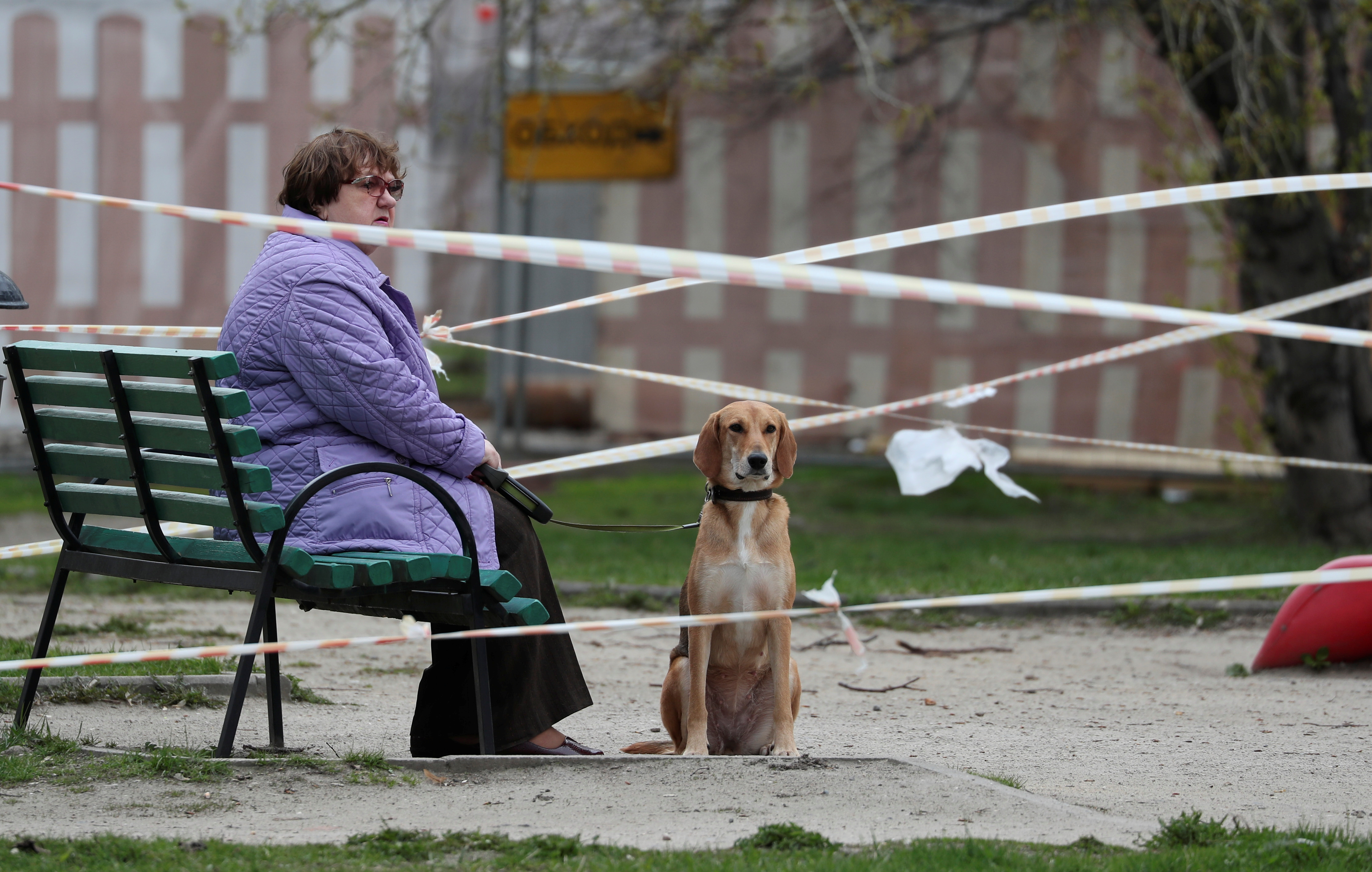 Una mujer pasea a su perro en un parque clausurado de la capital (Reuters)