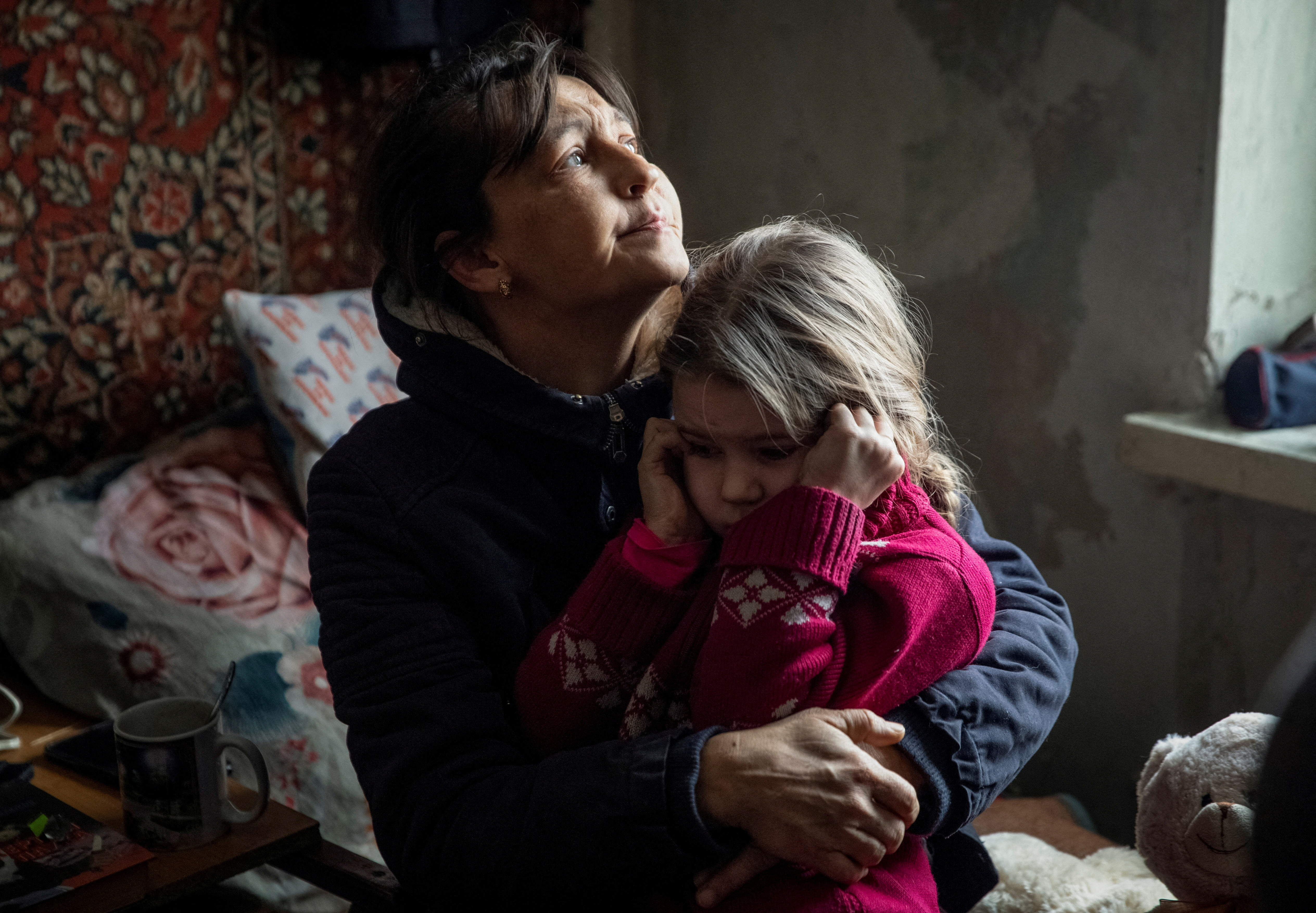 La abuela Olha abraza a su nieta Arina, de seis años, mientras espera a ser evacuada de Bakhmut, donde se registran sangrientos combates. (REUTERS/Oleksandr Ratushniak)     