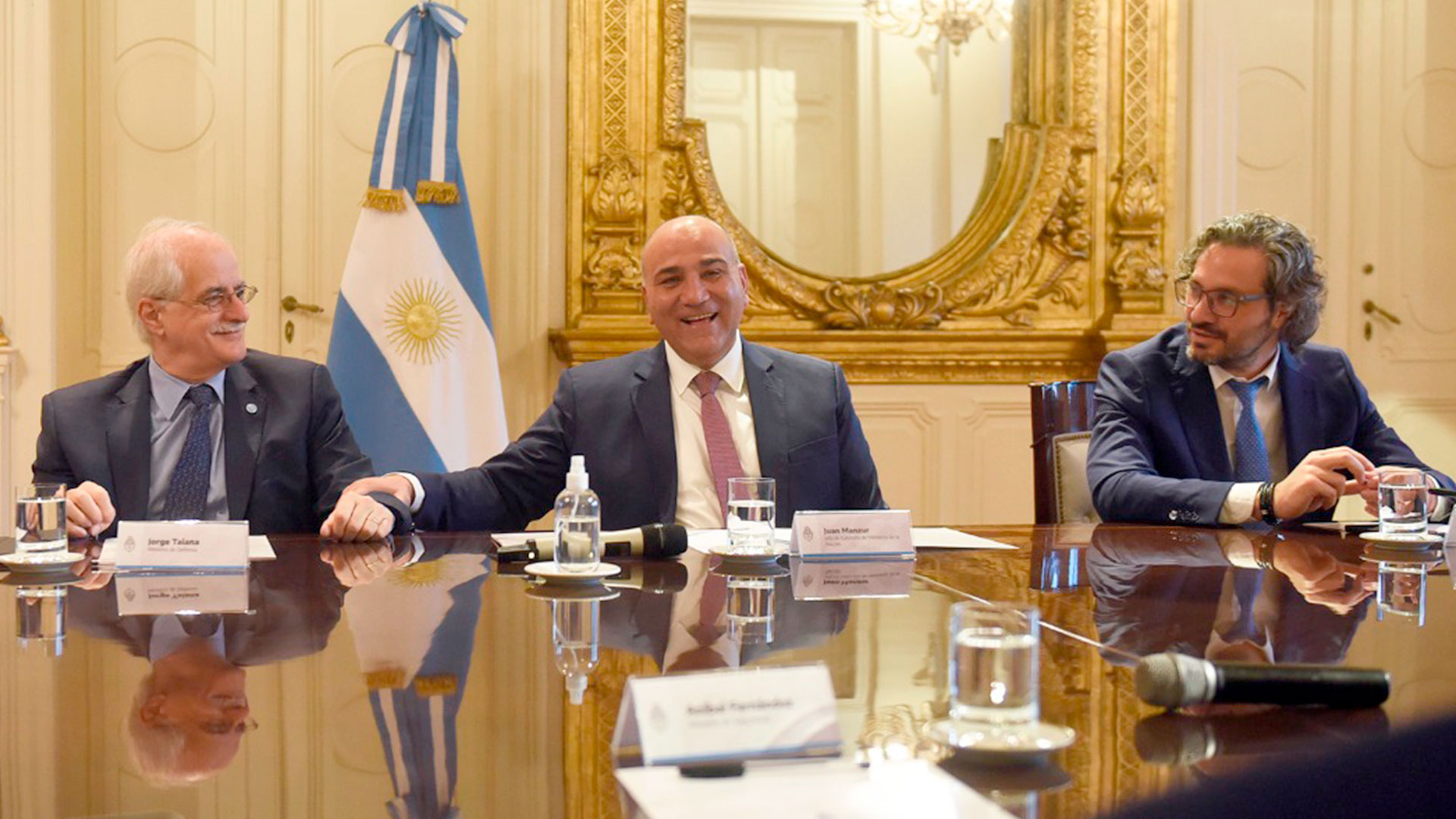 Juan Manzur sonríe acompañado por Jorge Taiana y Santiago Cafiero