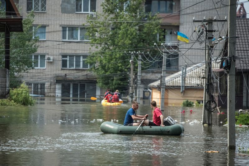 Residentes locales navegan en botes en una calle inundada durante una evacuación de una zona inundada tras la rotura de la presa de Nova Kajovka, en medio del ataque de Rusia a Ucrania, en Kherson, Ucrania. 8 de junio de 2023. REUTERS/Vladyslav Musiienko