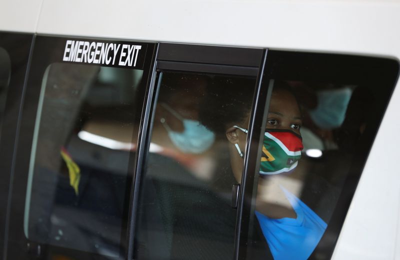 Una pasajera en un taxi lleva una máscara facial con los colores de la bandera sudafricana tras el anuncio de la prohibición británica de los vuelos desde Sudáfrica por la detección de una nueva variante de la enfermedad del coronavirus (COVID-19), en Soweto, Sudáfrica. 26 de noviembre de 2021 (REUTERS/Siphiwe Sibeko)