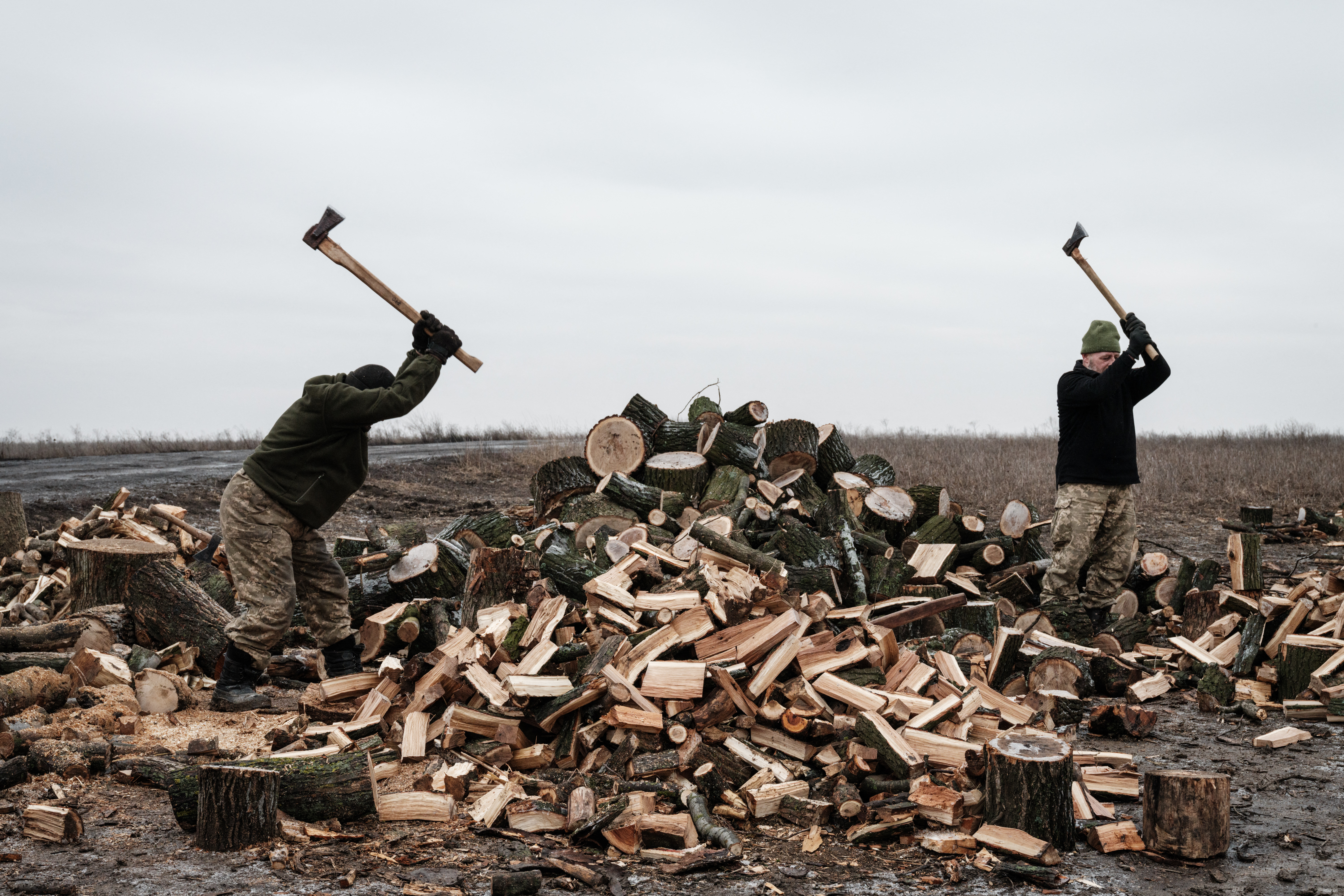 Otros militares ucranianos cortan madera para fortalecer las trincheras cavadas en el suelo endurecido por el frío, y dar un poco de calor a las tropas (YASUYOSHI CHIBA / AFP)
