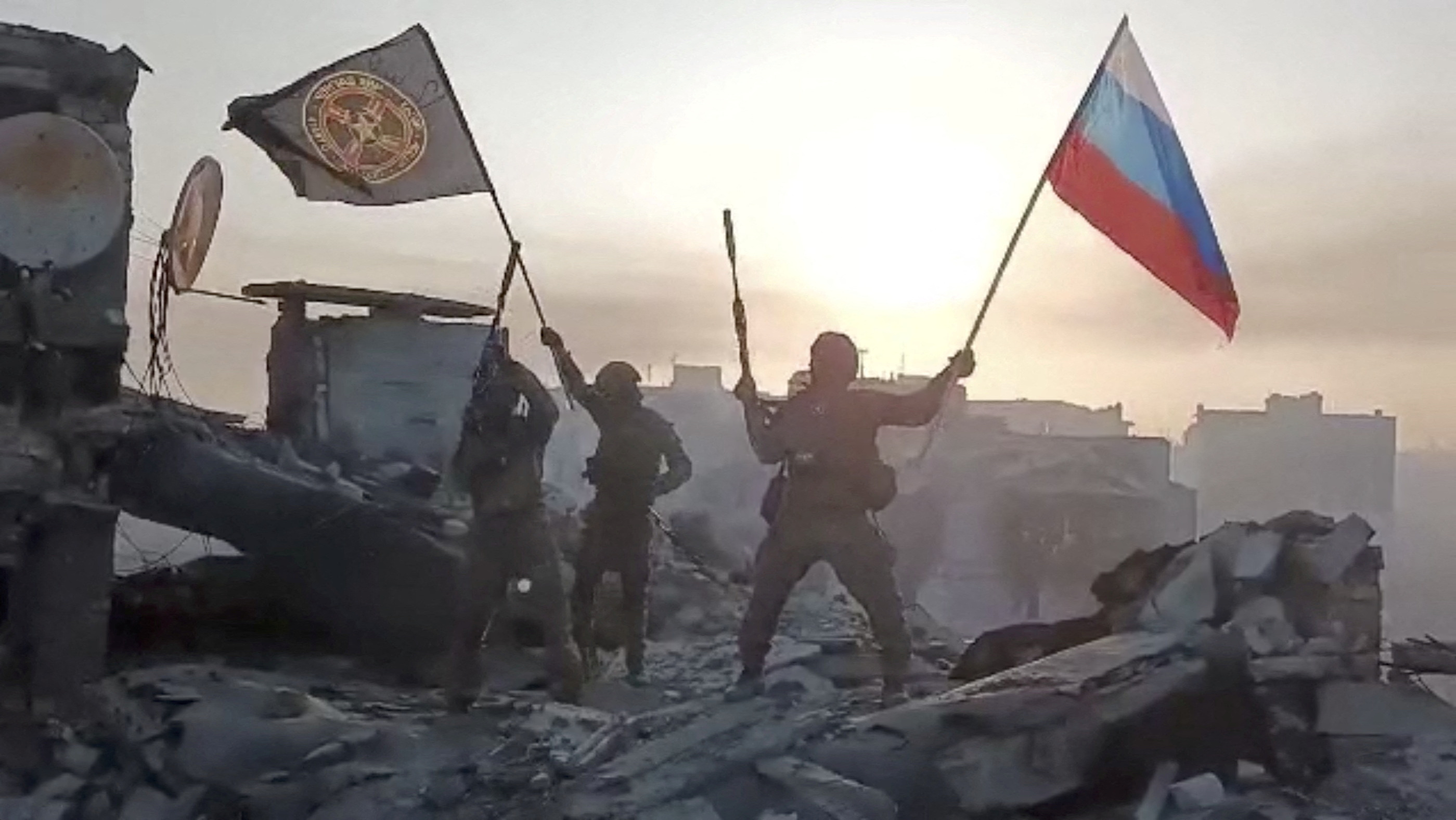 Mercenarios del grupo Wagner liderados por el amigo de Vladimir Putin, Yevgeny Prigozhin, enarbolan las banderas rusa y del batallón tras la conquista de un sector derruido de la ciudad de Bakhmut. (Press service of "Concord"/REUTERS) 