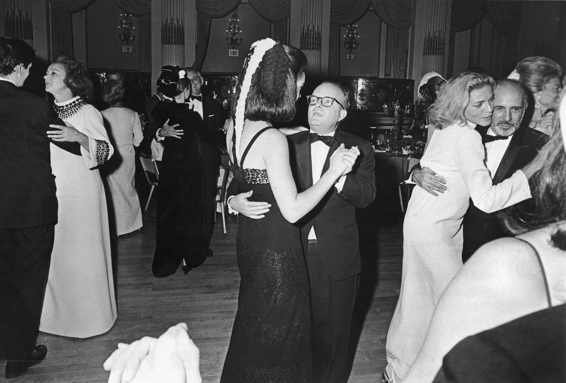 Truman en medio de la pista bailando con una de las invitadas a su fastuosa fiesta. A su lado, la incomparable Laureen Bacall junto al coreógrafo Jerome Robbins (Photo by Express Newspapers/Getty Images)    
