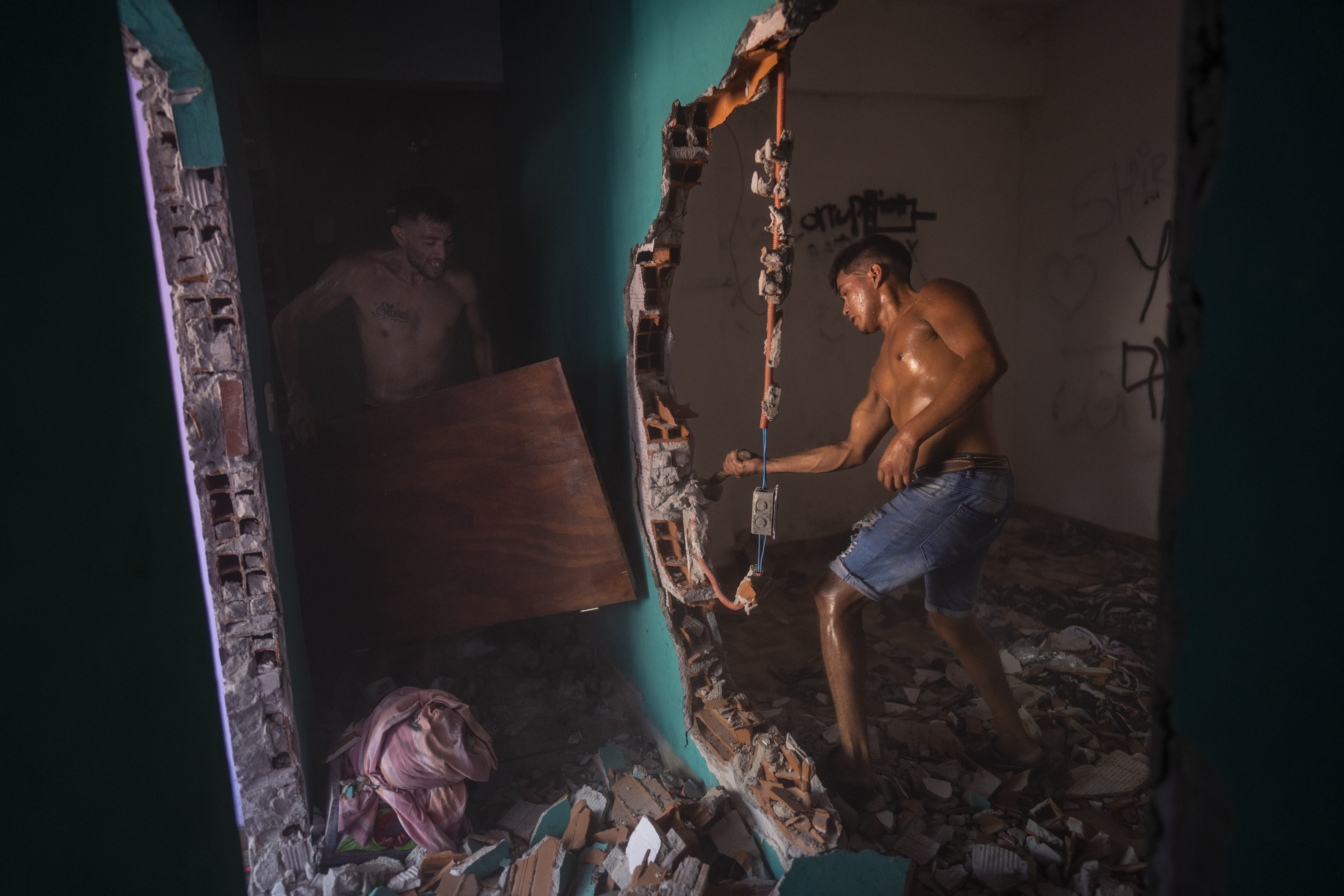 Vecinos y familiares de Máximo Jerez, un niño de 11 años que fue asesinado cuando al menos un pistolero atacó su fiesta de cumpleaños, destruyen la vivienda del supuesto agresor, en el vecindario de Los Pumitas, en Rosario, Argentina, el 6 de marzo de 2023. (AP Foto/Rodrigo Abd)