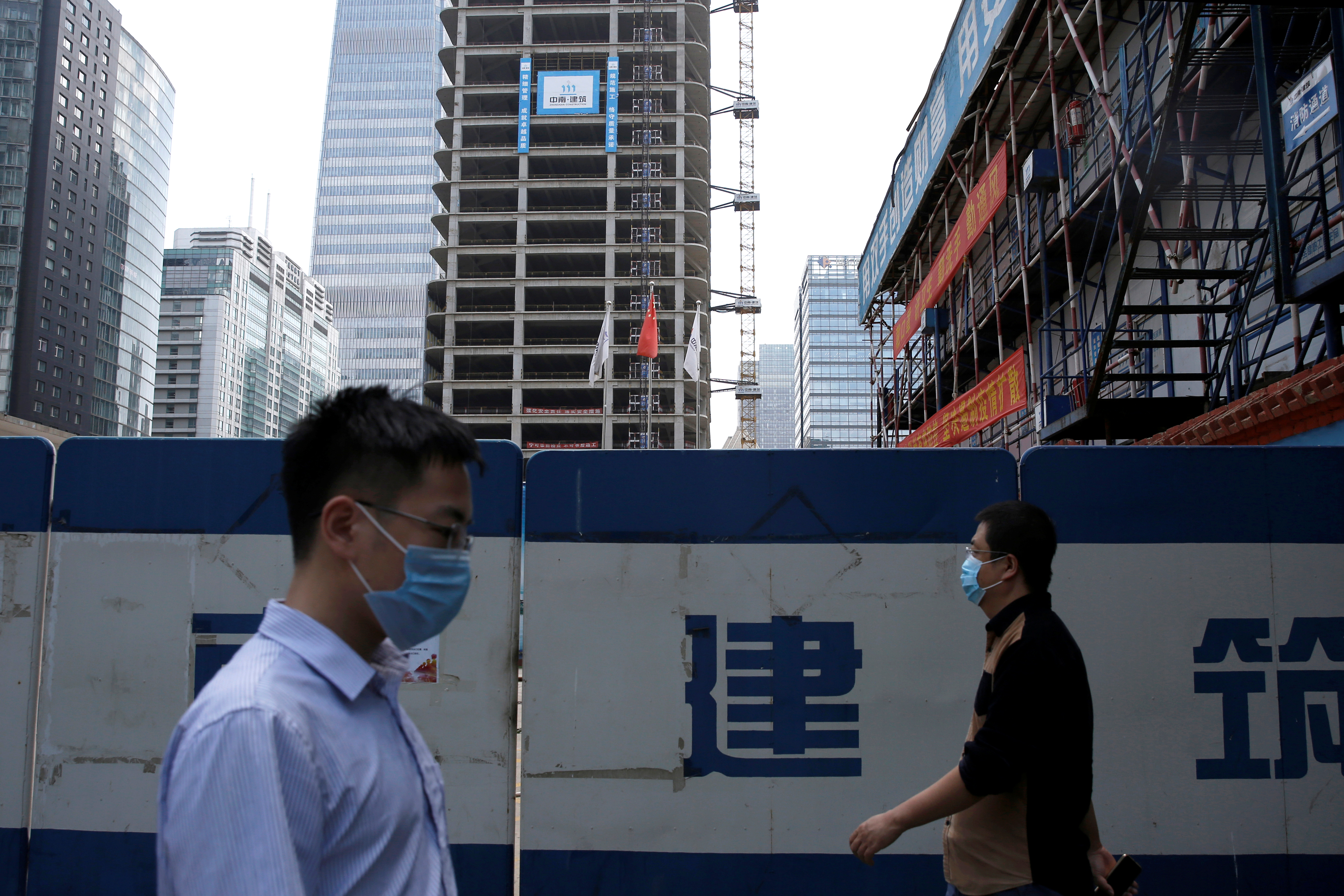 Dos personas caminan con barbijo en Beijing, en pleno brote de coronavirus (Reuters/ Tingshu Wang)