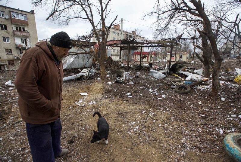 Un residente local camina con un perro en un patio de su edificio de apartamentos dañado, durante el ataque de Rusia contra Ucrania, en Bajmut, región de Donetsk, Ucrania, 5 de enero 2023. REUTERS/Anna Kudriavtseva/Archivo
