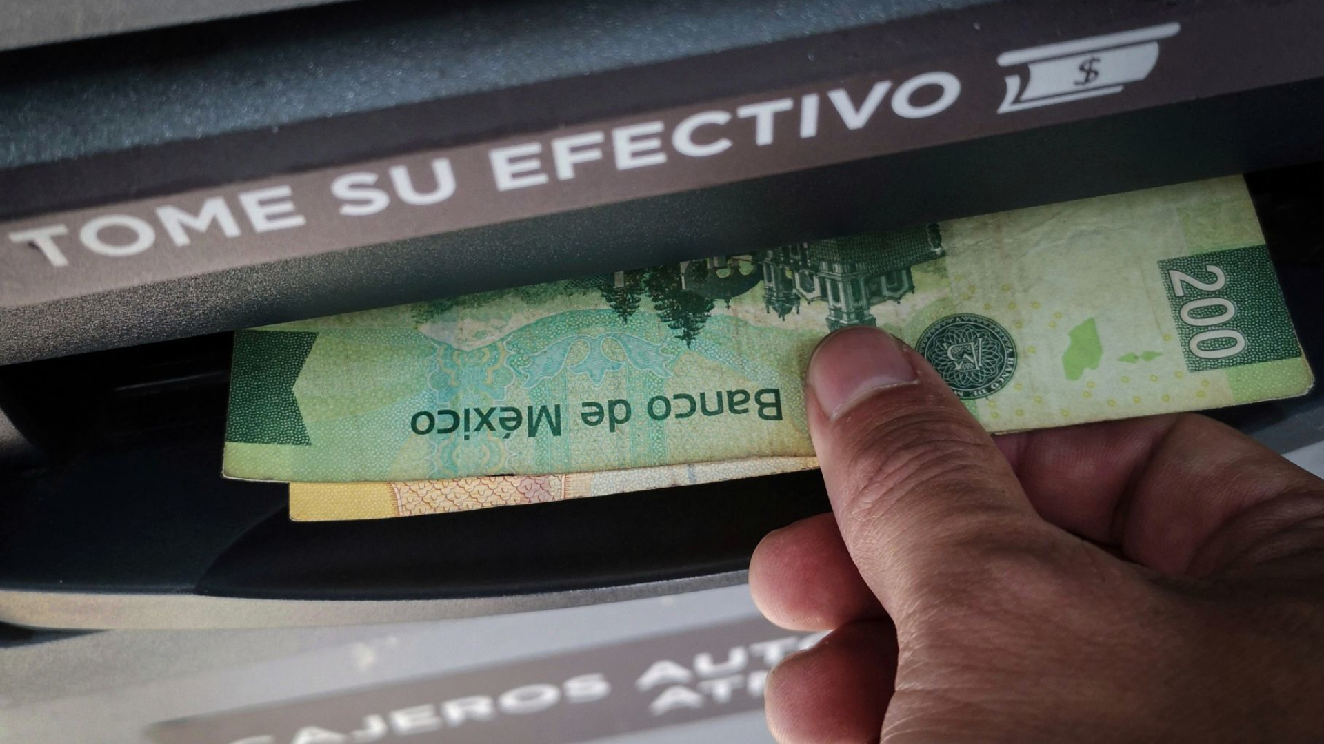 Una persona toma parte de su dinero en un cajero automático. (Foto: Cuartoscuro)
