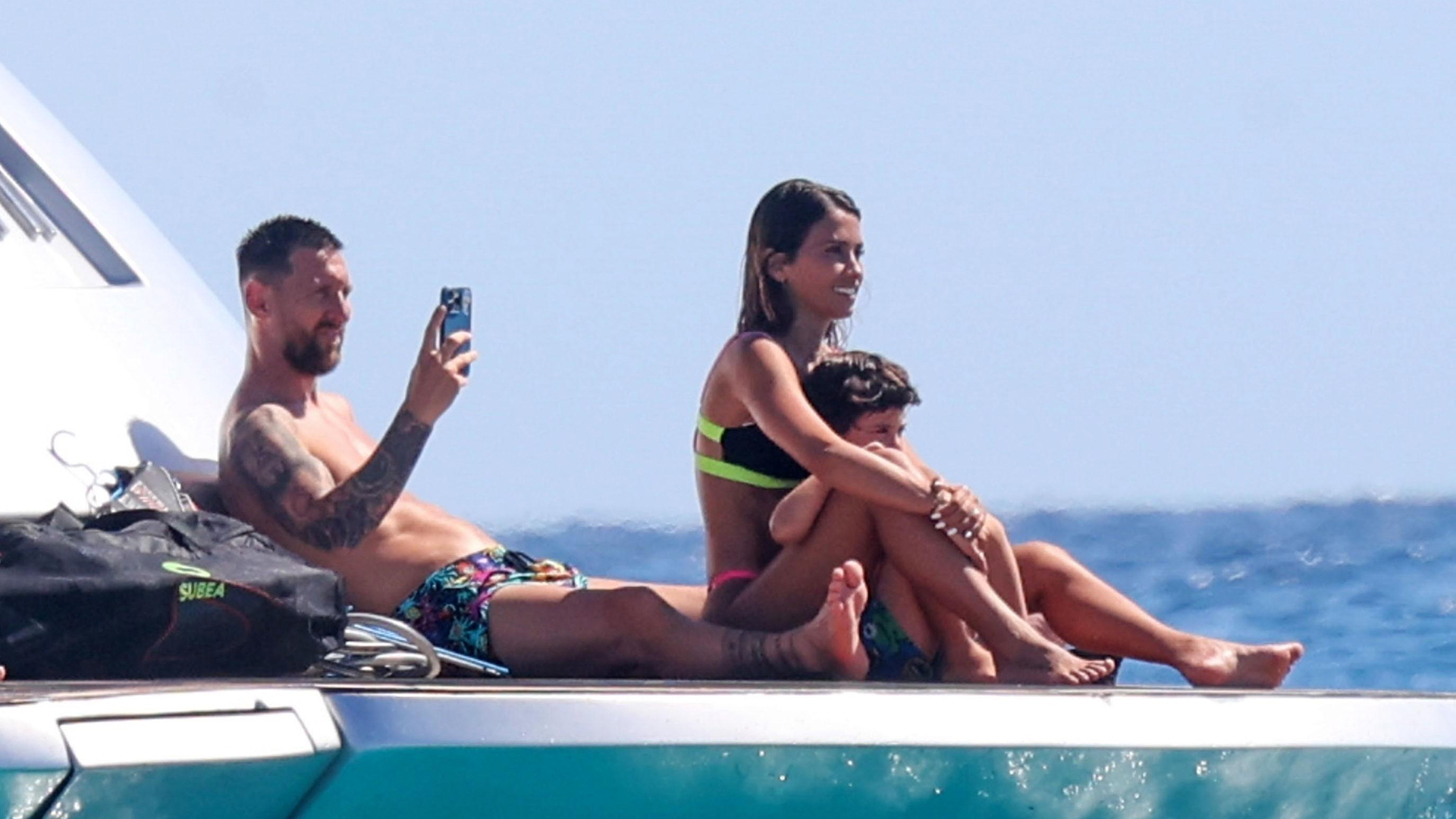 Leo toma una foto con su celular, mientras descansa con su esposa y uno de sus tres hijos