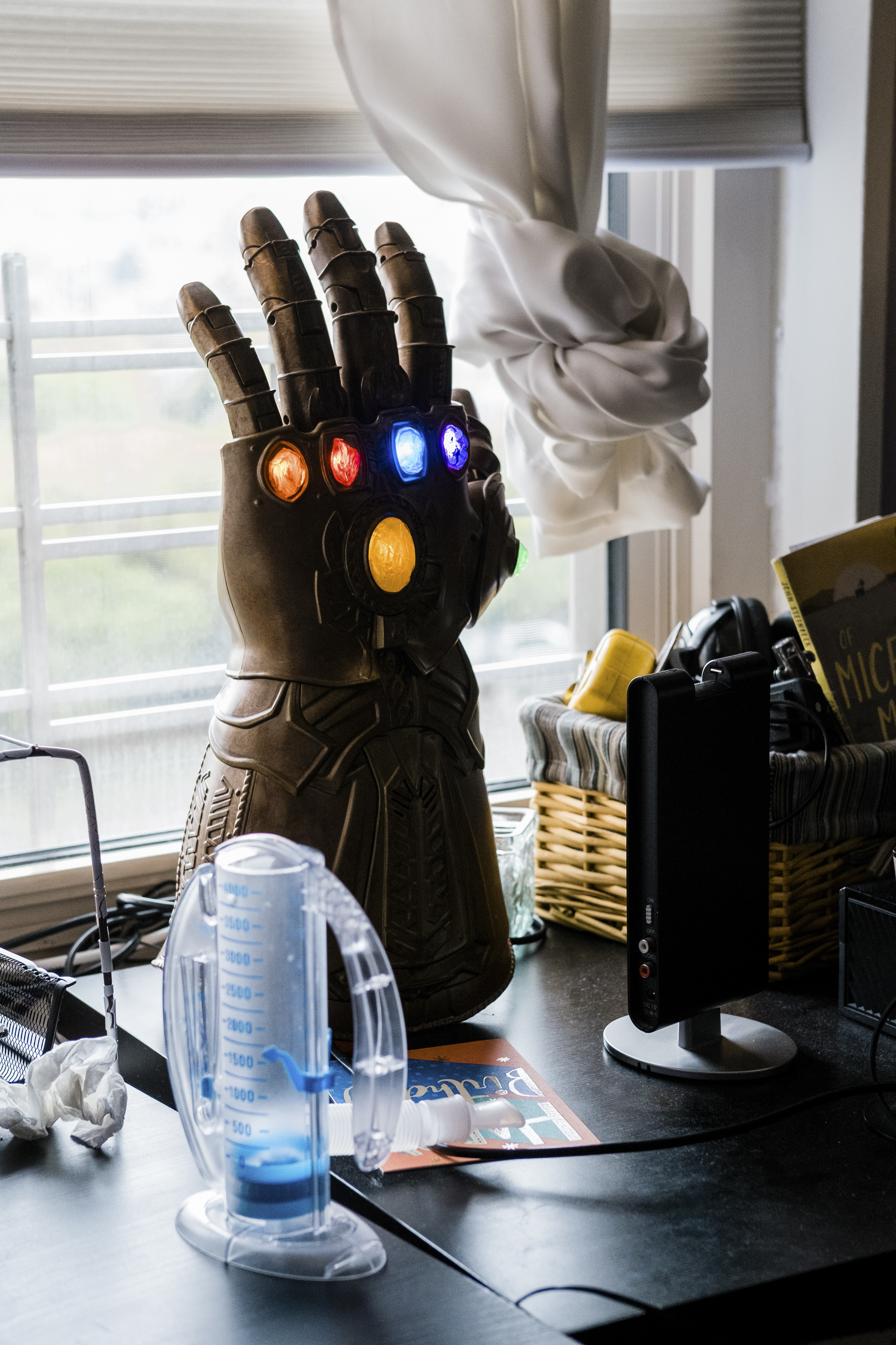 Un espirómetro de incentivo -para mejorar el funcionamiento de los pulmones- en el escritorio de Jack McMorrow junto con un Infinity Gauntlet de las películas de los Vengadores (Gabriela Bhaskar / The New York Times)