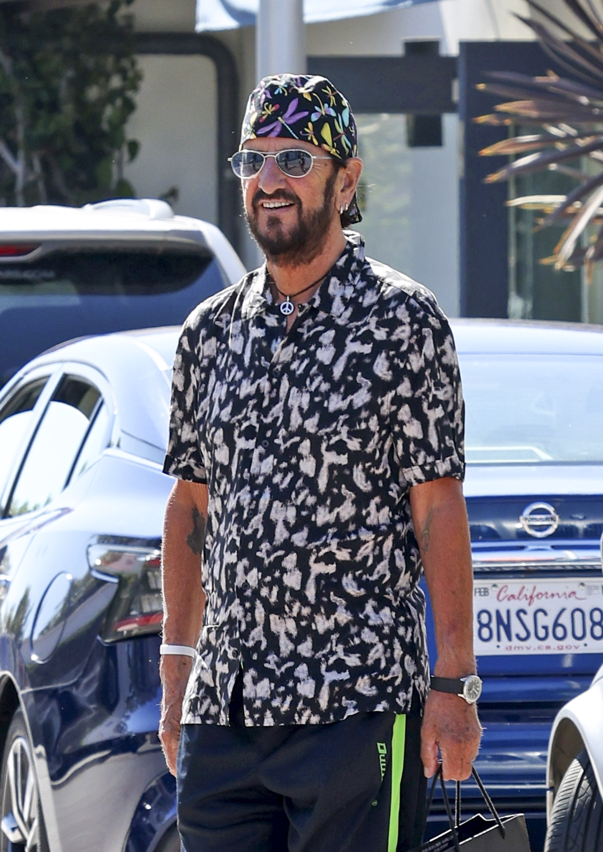 La leyenda del rock Ringo Starr se despide de algunos amigos después de ir de compras con su esposa Barbara Bach, en Malibú. El ex Beatle lució renovado con una camisa estampada combinada con un pañuelo en su cabeza, también estampado