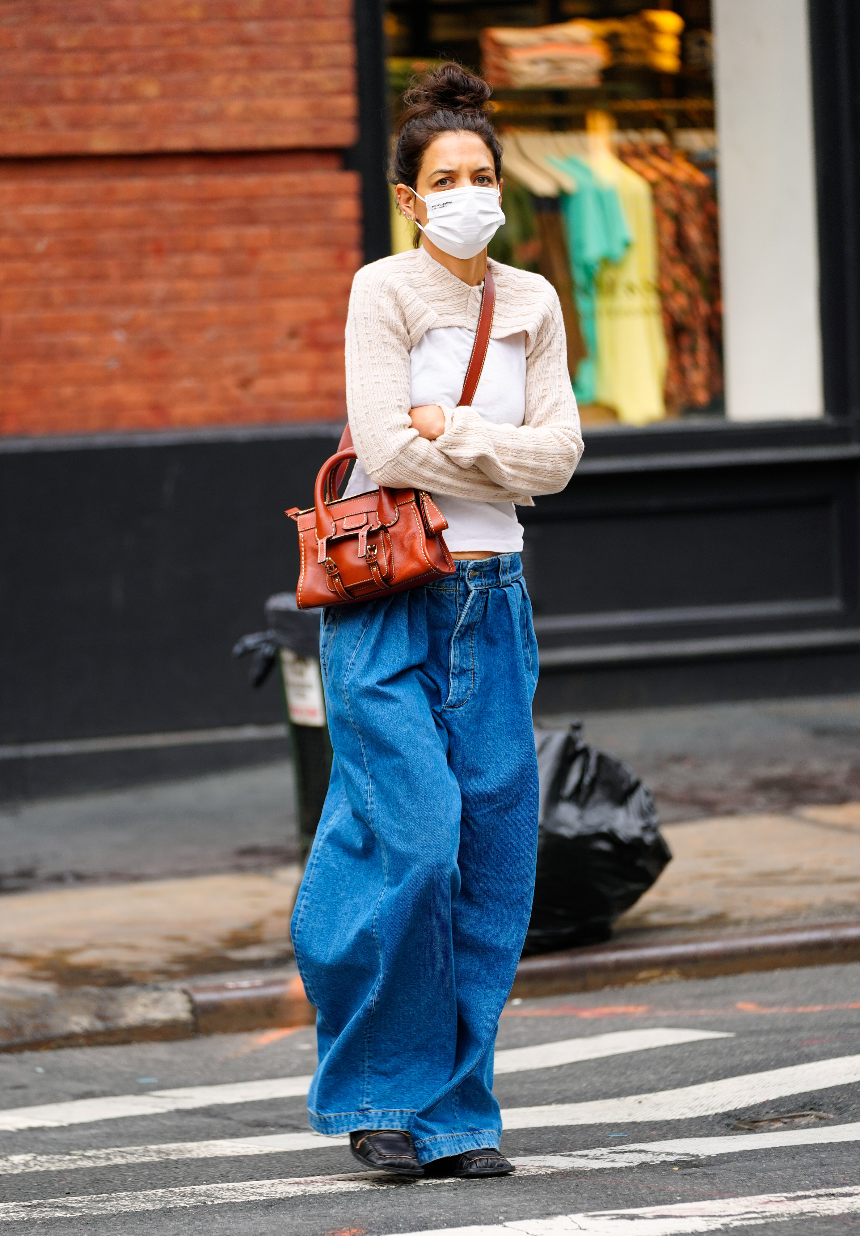 Katie Holmes fue fotografiada mientras daba un paseo por las calles de Nueva York. La actriz lució un jean oversize, un sweater clarito que combinó con su tapabocas, y una cartera marrón de cuero