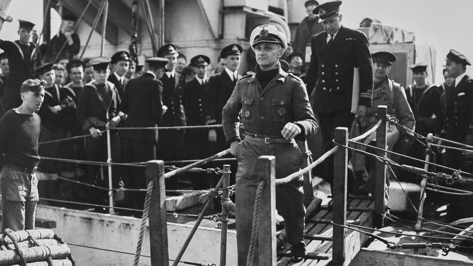 Helmut Dauter (1919 - 1987), comandante de la Kriegsmarine nazi, sale de un submarino tipo VIIIC, el U-448, escoltado por el teniente Jack Bathurst (Getty Images)
