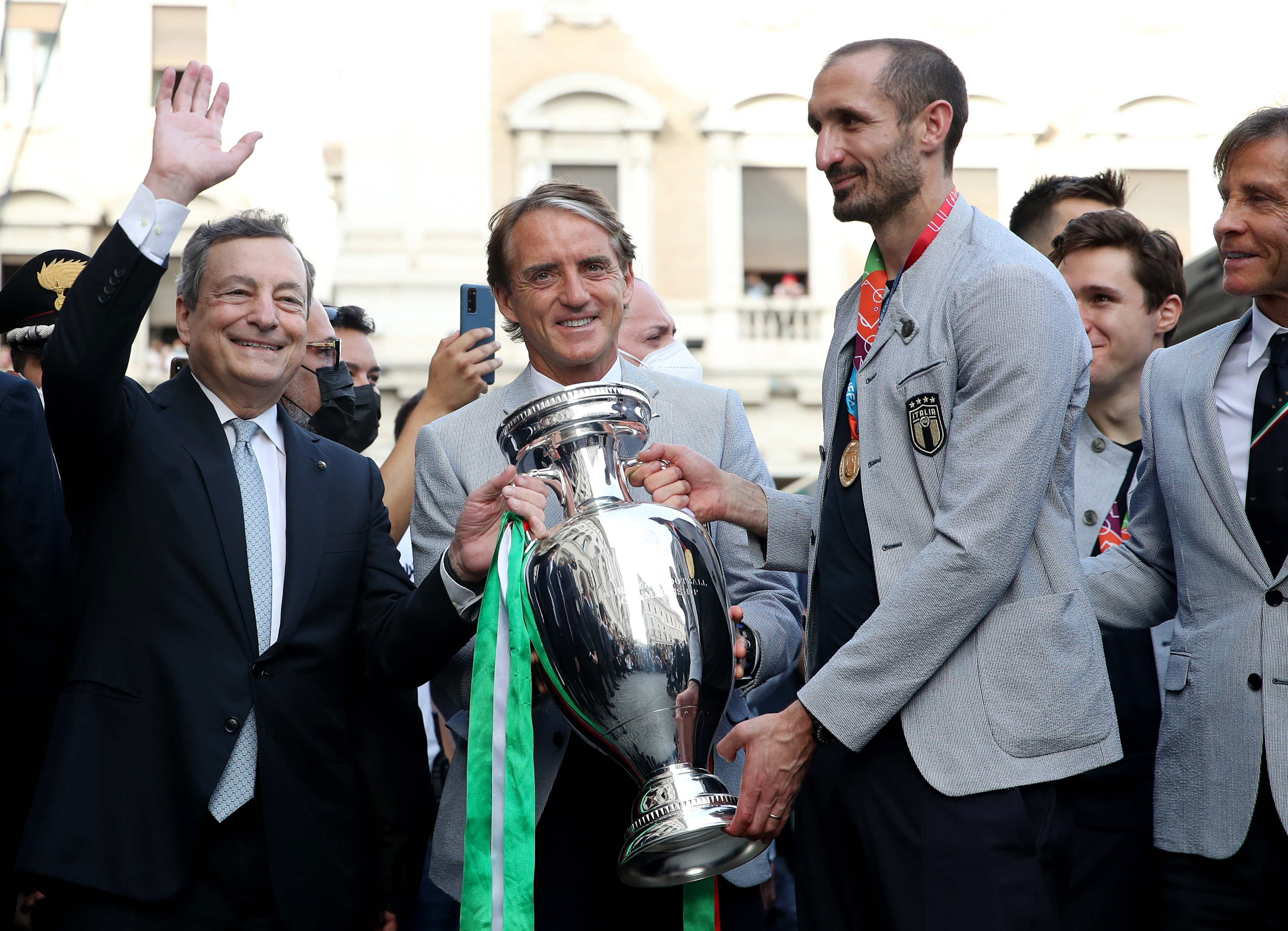 Giorgio Chiellini y Roberto Mancini posan con el trofeo de la Eurocopa junto con el primer ministro italiano Mario Draghi (REUTERS/Yara Nardi)