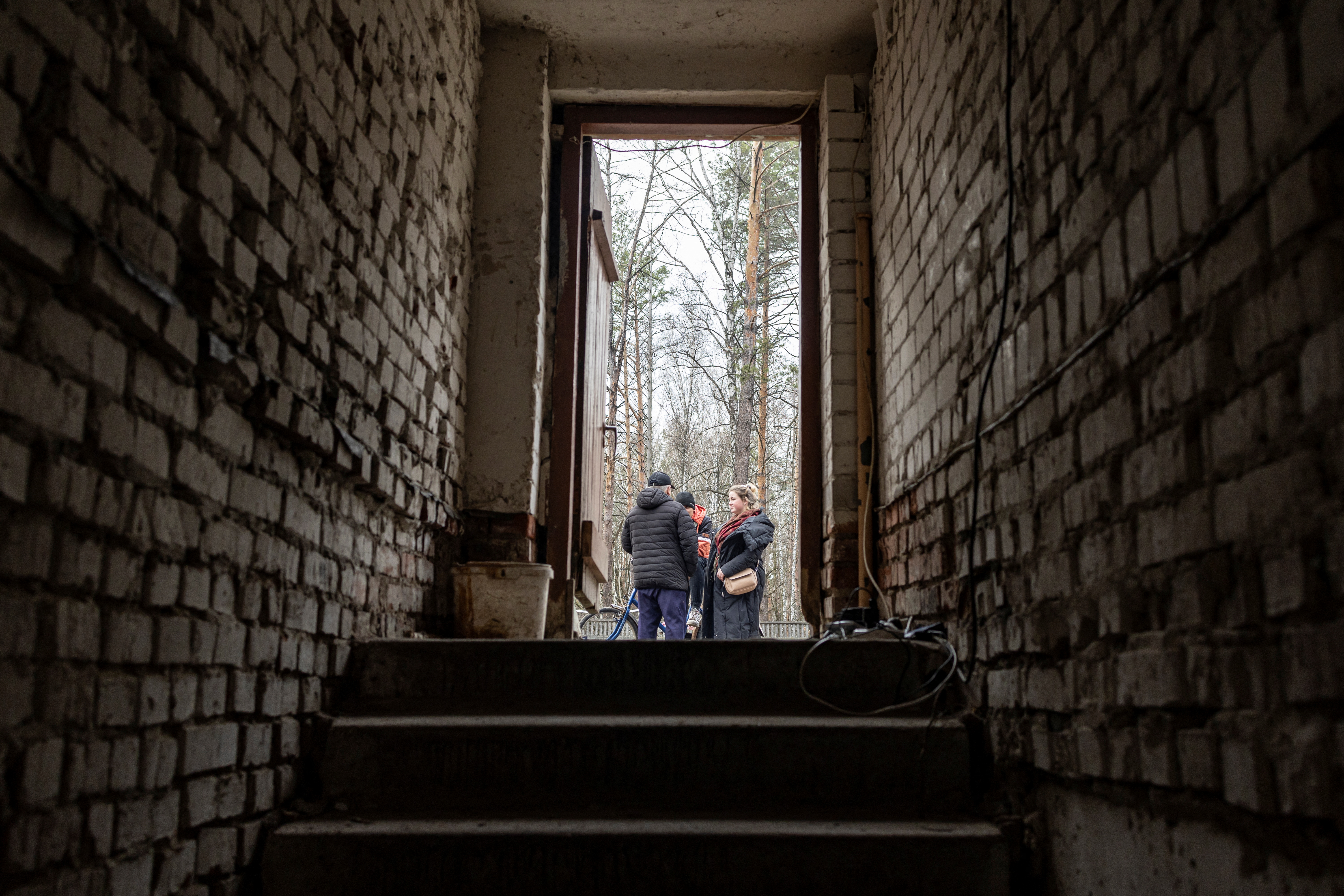 La gente se para fuera de la entrada al sótano de una escuela, mientras continúa la invasión rusa de Ucrania, en el pueblo de Yahidne, cerca de Chernihiv, Ucrania, el 6 de abril de 2022. REUTERS/Marko Djurica 