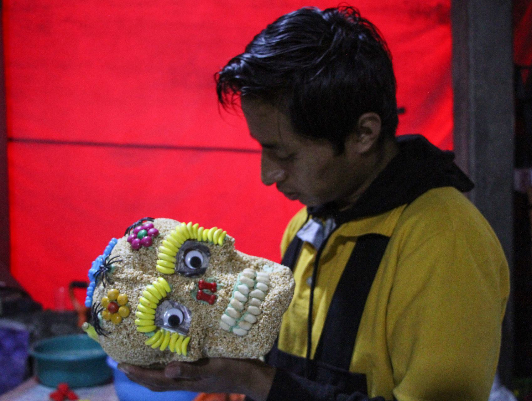 Productor de dulces tradicionales termina la decoración de una calaverita de amaranto en Xochimilco.