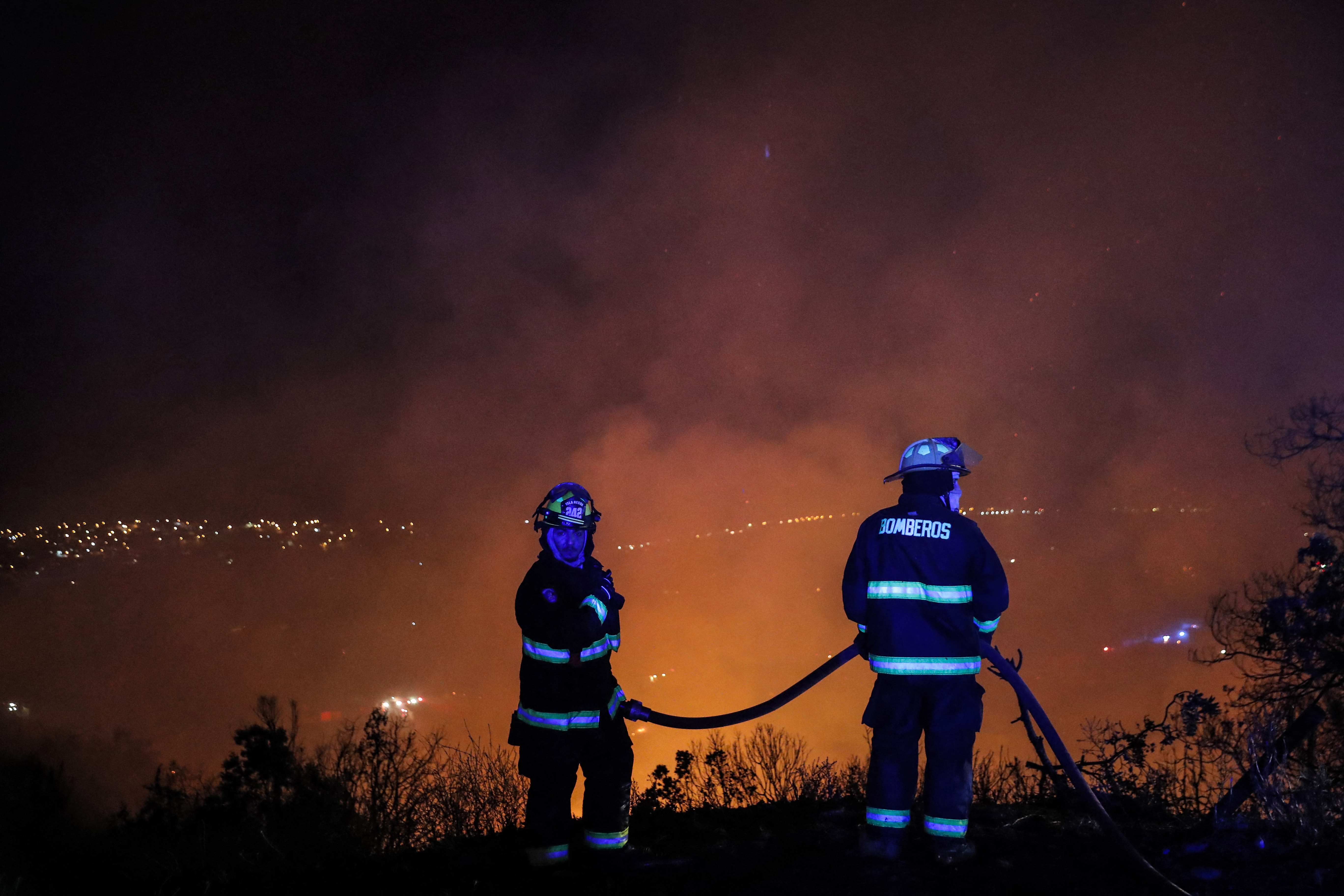 Dos bomberos en plena labor de combate del fuego (JAVIER TORRES / AFP)