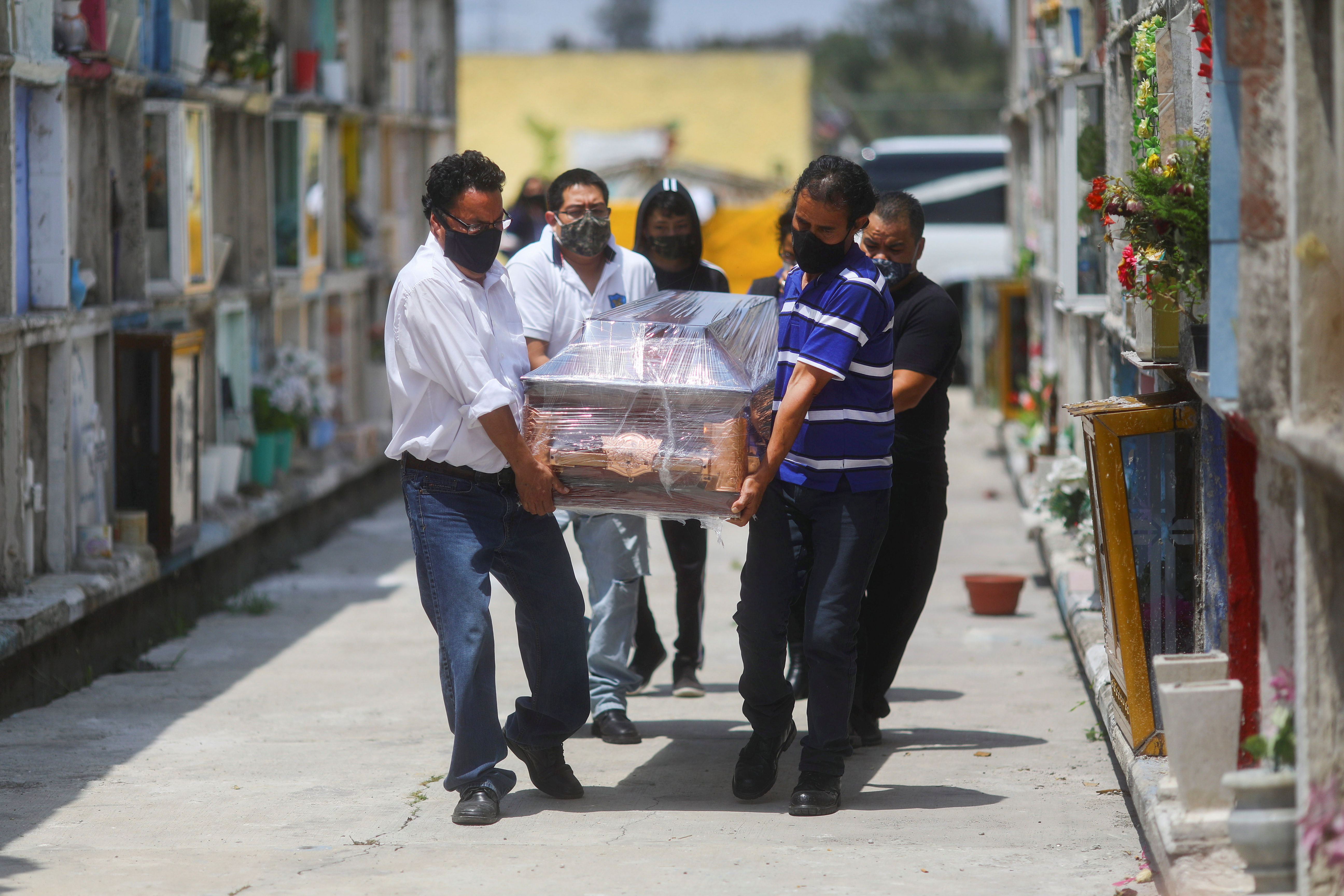 Parientes llevan el ataúd de María Eugenia, de 71 años, que murió de la enfermedad coronavirus (COVID-19), durante su funeral en el cementerio municipal de Nezahualcoyotl, Estado de México, México, el 21 de agosto de 2020. REUTERS/Edgard Garrido