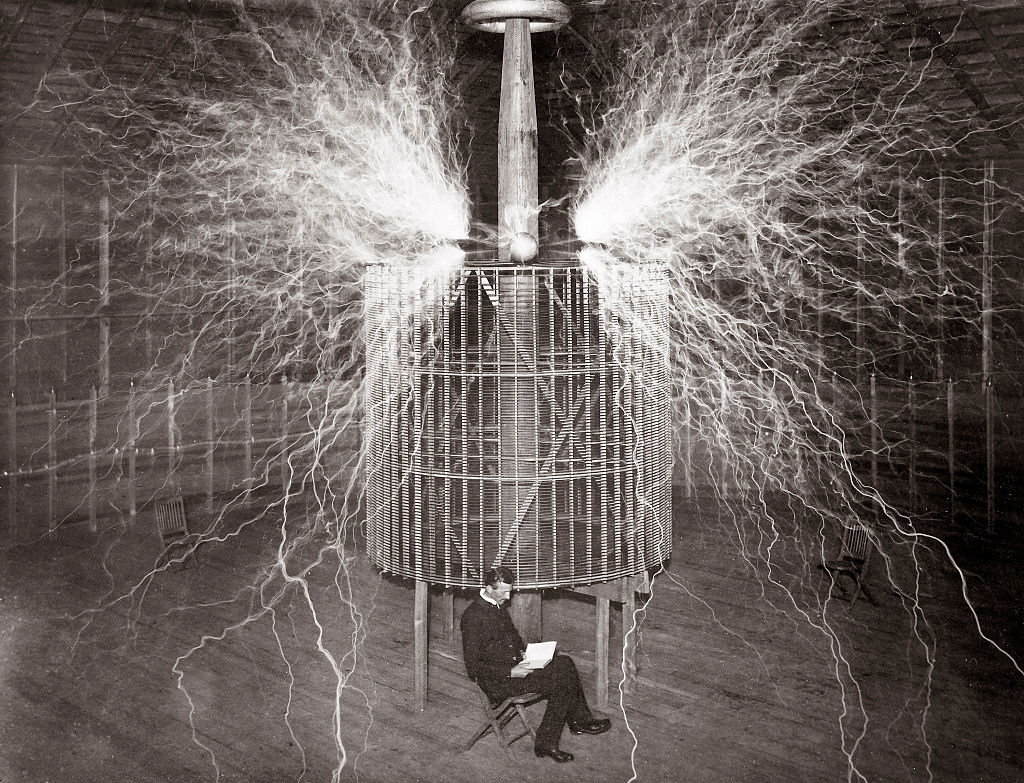 El físico Nikola Tesla sentado en su laboratorio de Colorado Springs con su "transmisor de aumento", en 1899 (Stefano Bianchetti/Corbis vía Getty Images)
