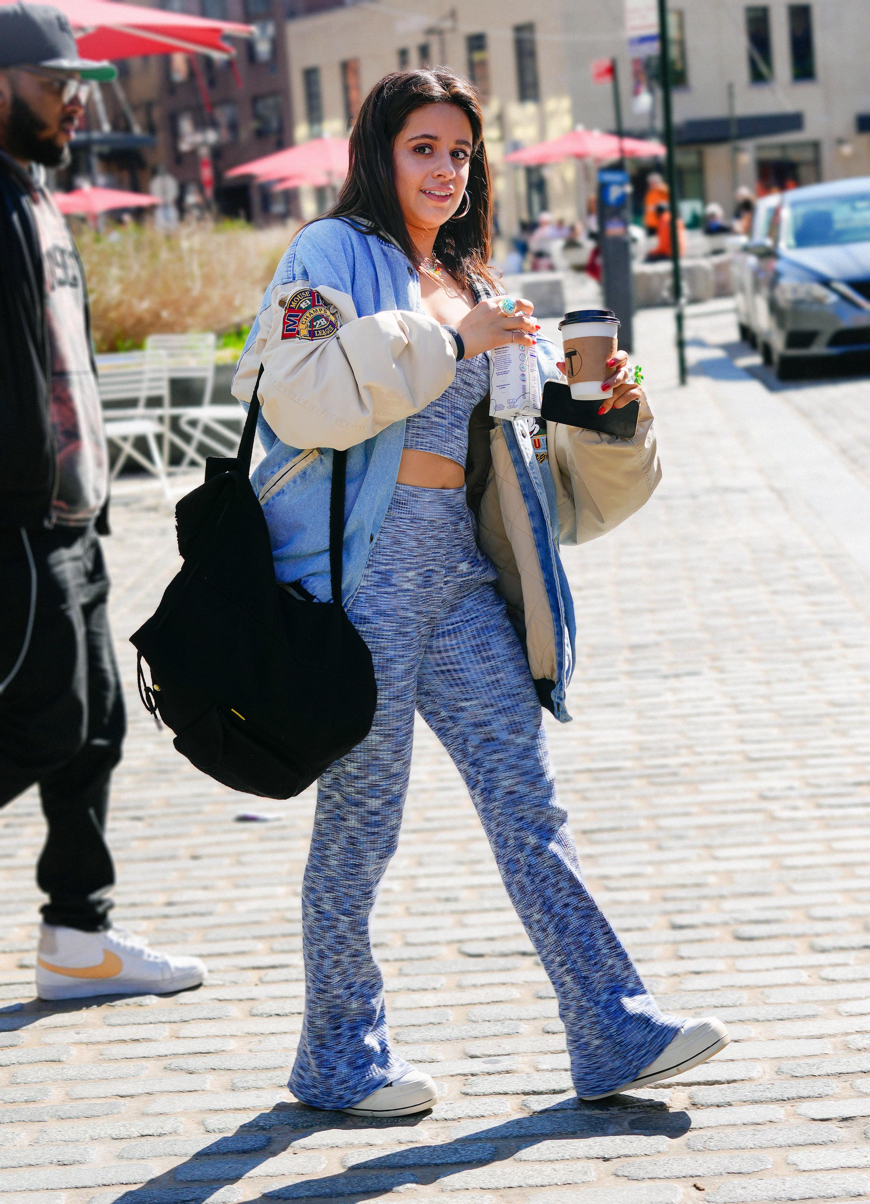 Camila Cabello fue fotografiada cuando salía del hotel en el que se hospeda por estos días en Nueva York. La artista cargó una mochila y un café para llevar, mientras la esperaba una camioneta para trasladarla. Lució un conjunto de top y pantalán celeste con una campera de jean