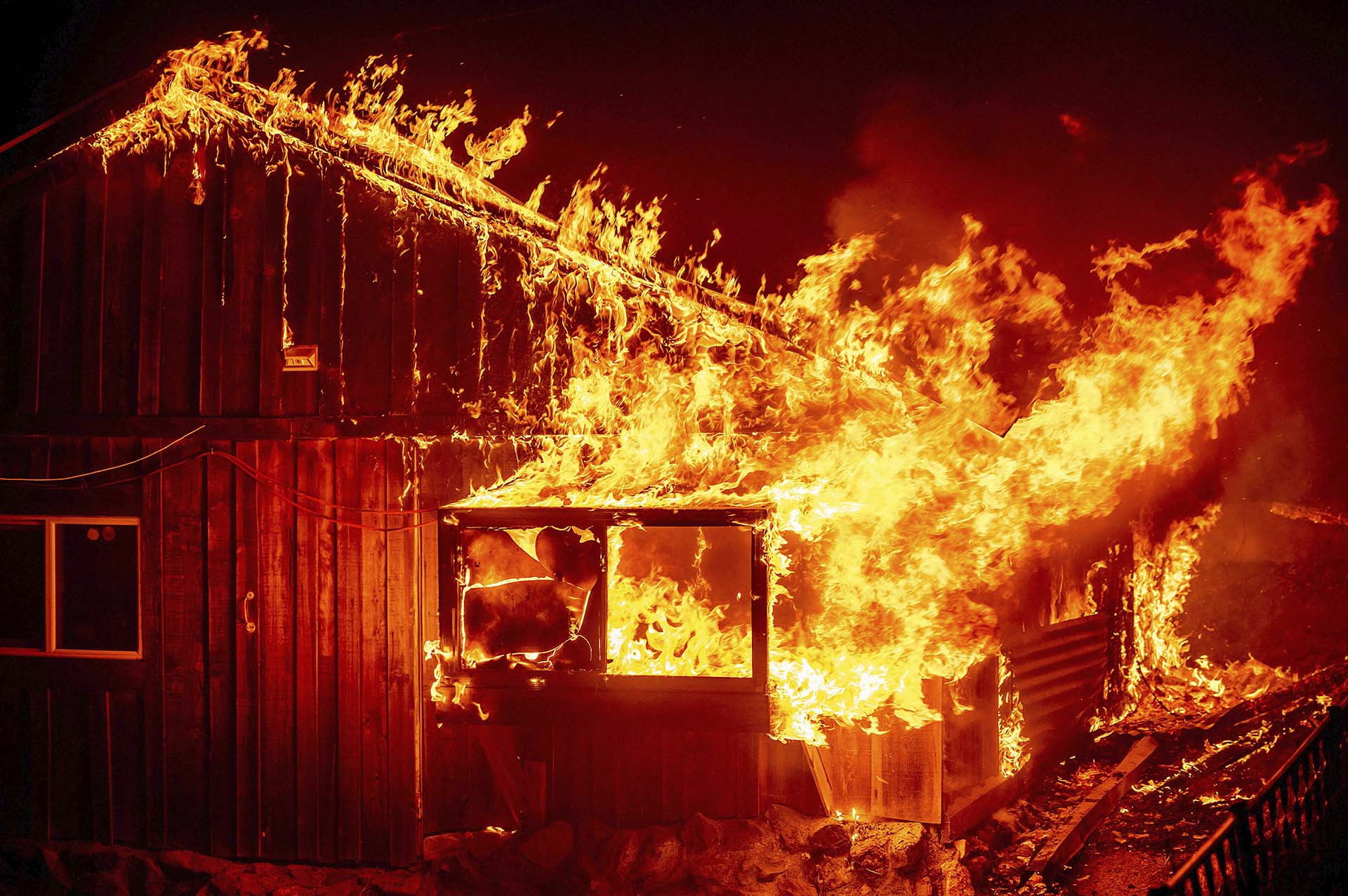 Las llamas se disparan desde una casa mientras el fuego arde a través del área de Berry Creek en el condado de Butte, California, el miércoles 9 de septiembre de 2020 (Foto AP/Noah Berger)