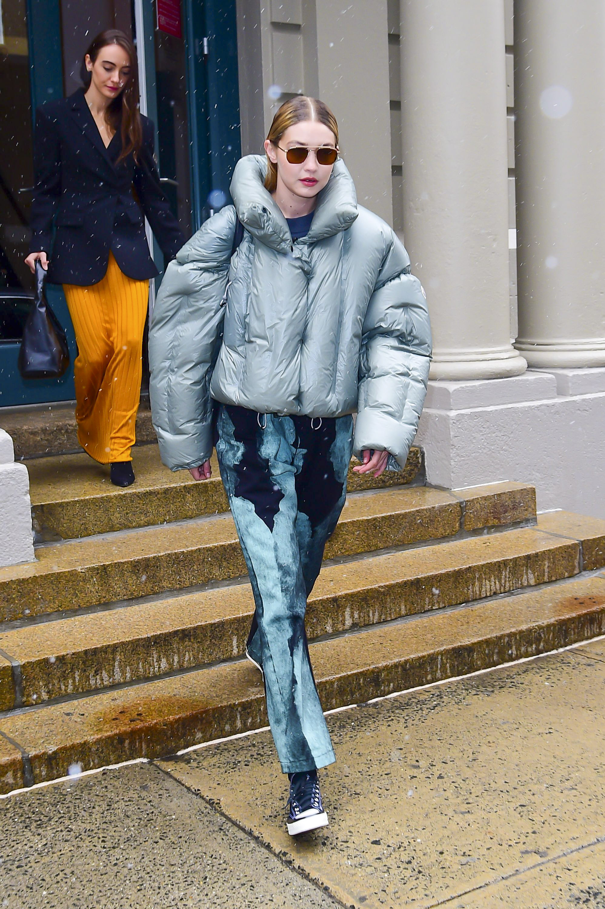Gigi Hadid asistió al New York Fashion Week y marcó tendencia con su look: lució un pantalón de jean intervenido en la gama del azul y una campera de pluma color celeste