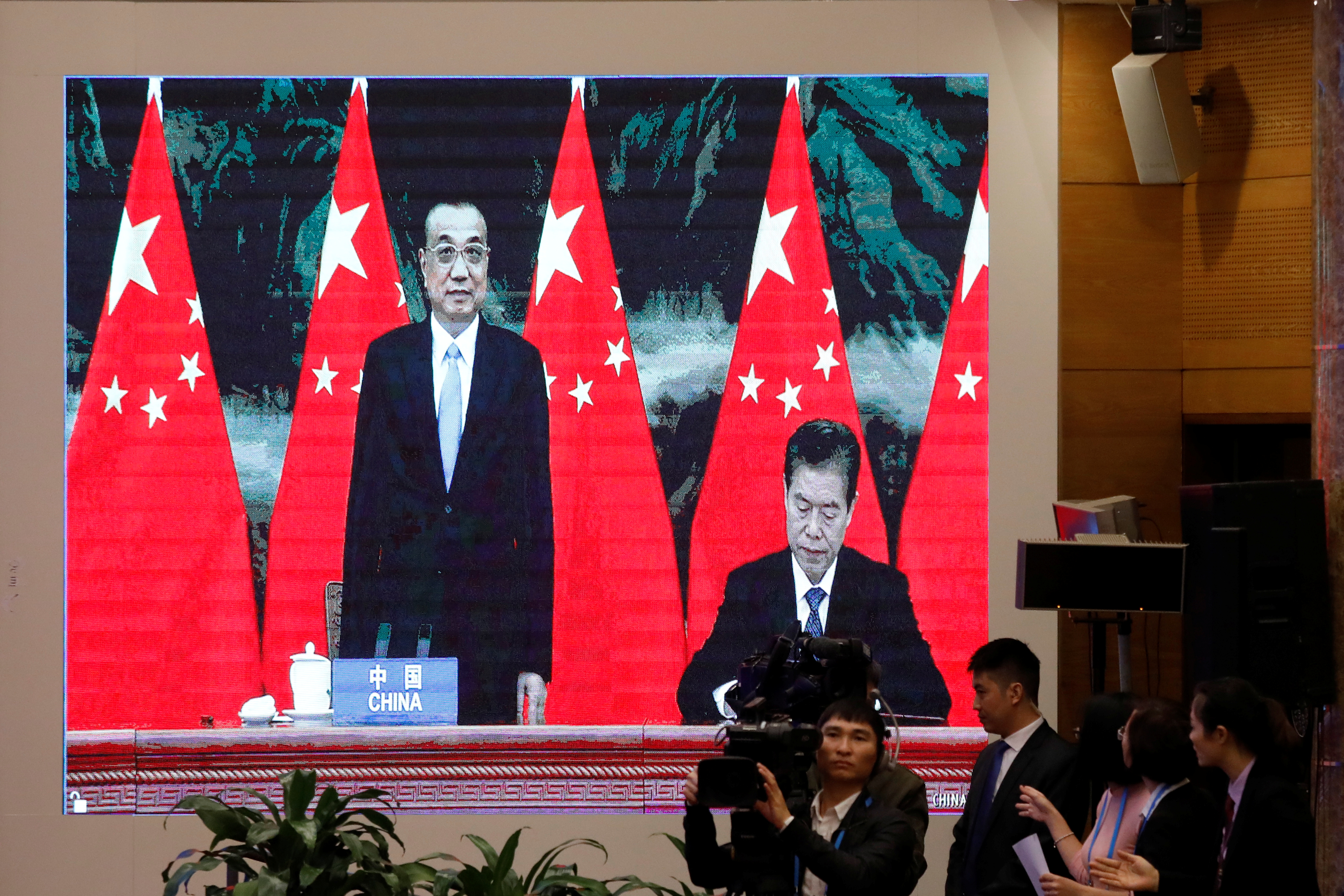 Una pantalla muestra al ministro de comercio chino Zhong Shan junto al primer ministro Li Keqiang durante la firma del tratado. Foto: REUTERS/Kham