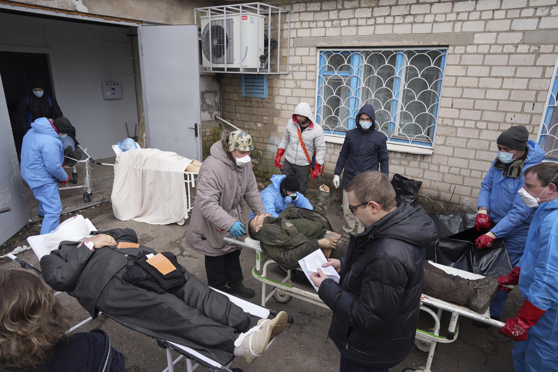 Los cadáveres son preparados antes de ser enterrados en una fosa común en las afueras de Mariupol (AP Photo/Evgeniy Maloletka)