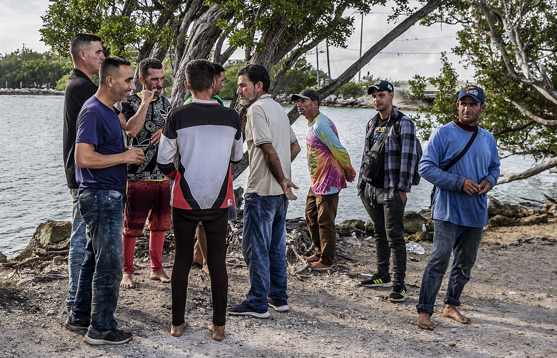 Un grupo de migrantes cubanos se reúne cerca de un camino en la isla Duck Key el lunes (Pedro Portal/Miami Herald vía AP)