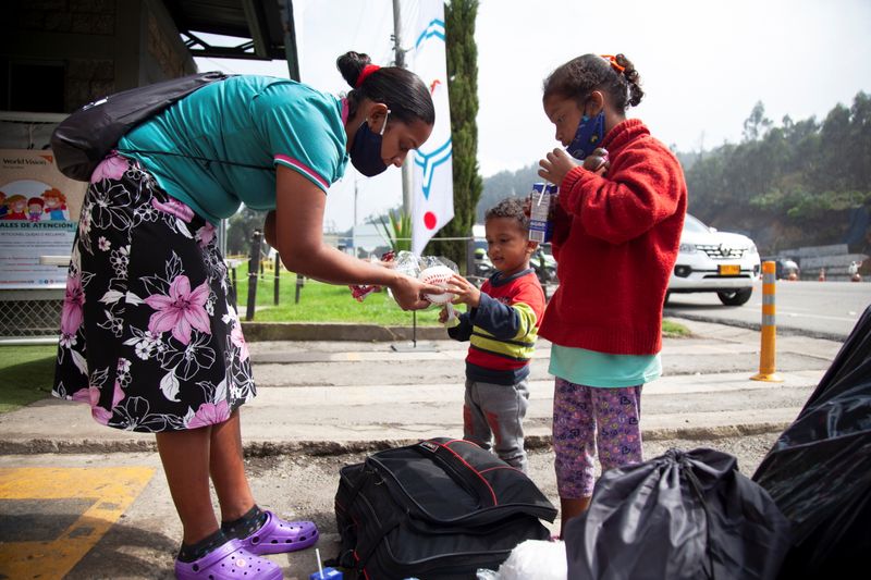 Una mujer migrante venezolana entrega juguetes a sus hijos mientras participan en el proyecto Play to Dream del Comité Internacional de Rescate en un punto de atención en Chusacá, Colombia (REUTERS/Vannessa Jiménez/Archivo)