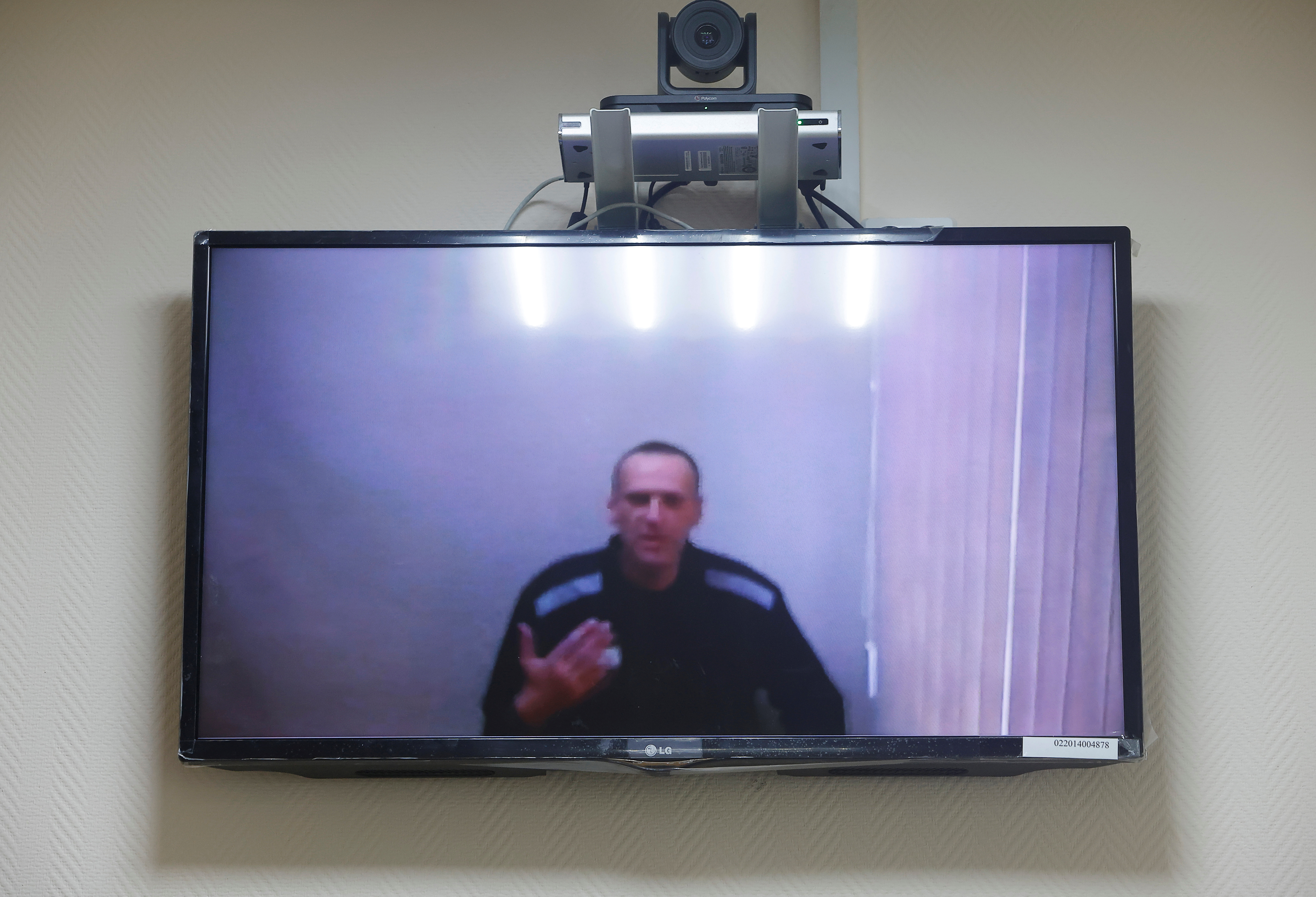 El líder de la oposición rusa Alexei Navalny es visto en una pantalla durante una audiencia para considerar sus demandas contra la colonia penal por las condiciones de detención allí, en el tribunal de distrito de Petushki en Petushki, Rusia, el 26 de mayo de 2021. (REUTERS / Maxim Shemetov)