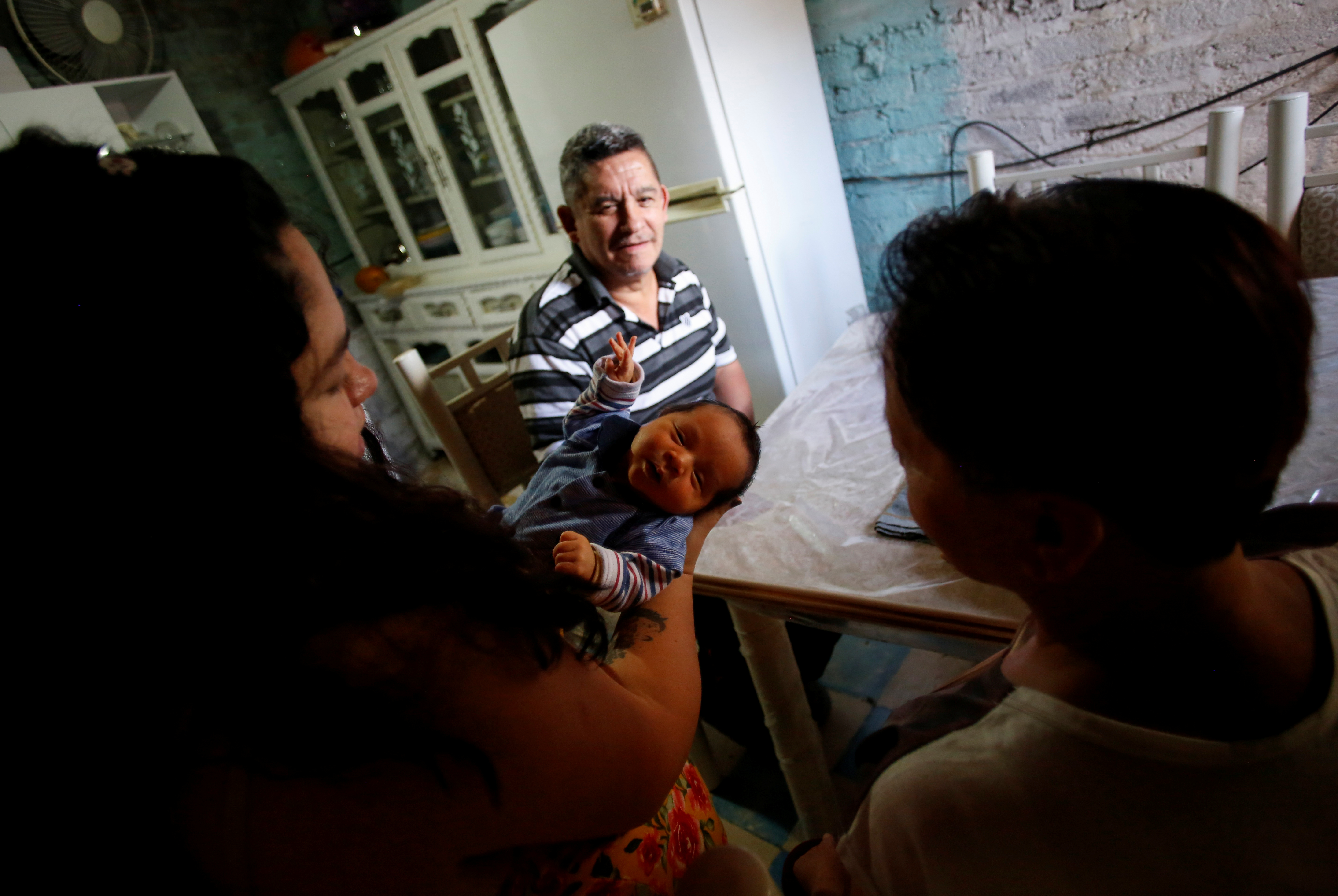 Jesús Carlos López mira a su hija Karla López Rangel, de 24 años, que tuvo un parto en casa durante el brote de la enfermedad por coronavirus (COVID-19), mientras sostiene a su hijo recién nacido Sabino Yoehi Flores López junto a la madre de Karla, Maria Rangel Soriana, en Iztapalapa, Ciudad de México, México, 4 de junio de 2020. Foto: REUTERS / Gustavo Graf.