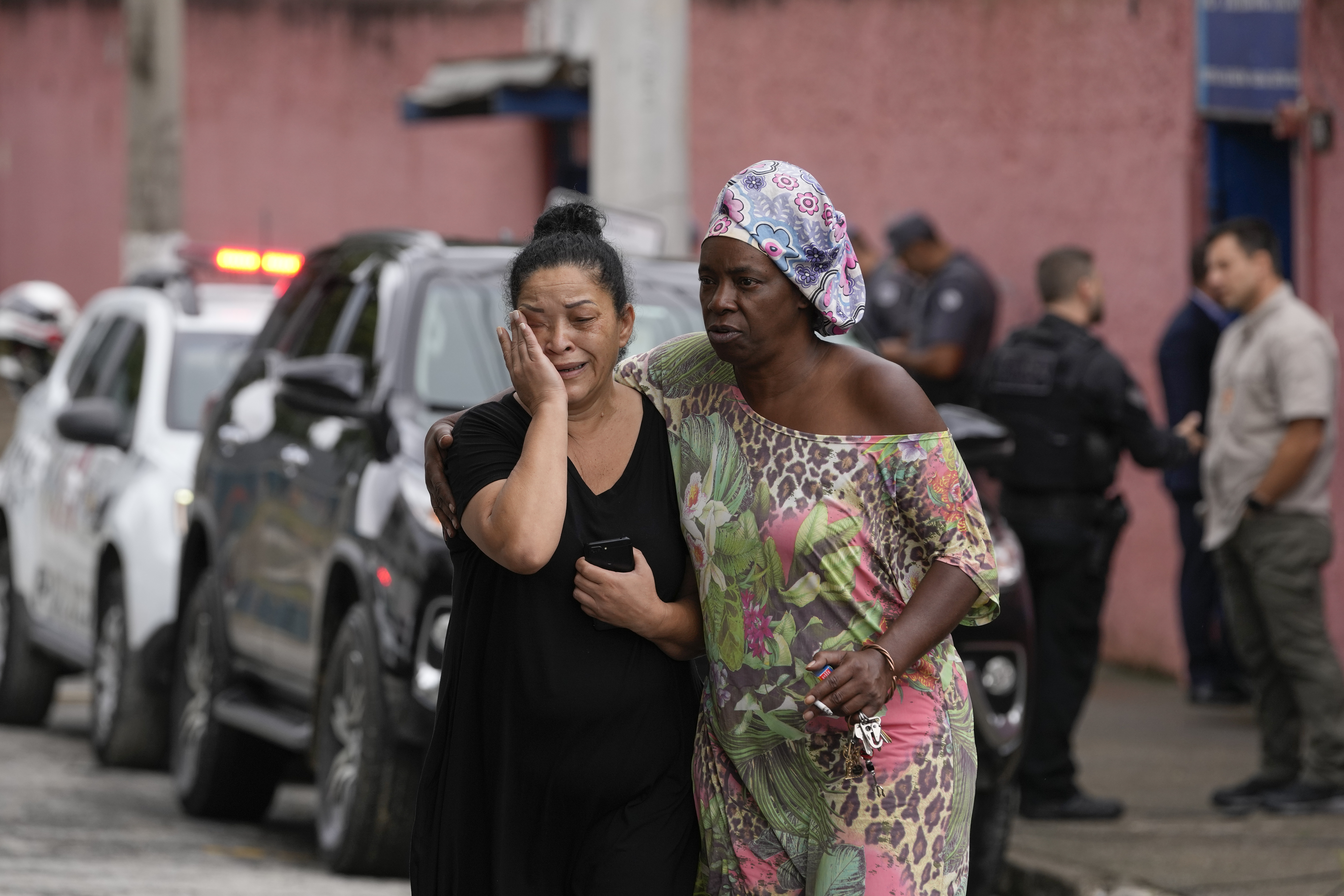Silvia Palmieri (izquierda), quien es madre de una maestra que sobrevivió a un ataque a puñaladas en la escuela Tomaia Montoro es consolada por una amiga el lunes 27 de marzo de 2023 en Sao Paulo, Brasil (AP Foto/Andre Penner)