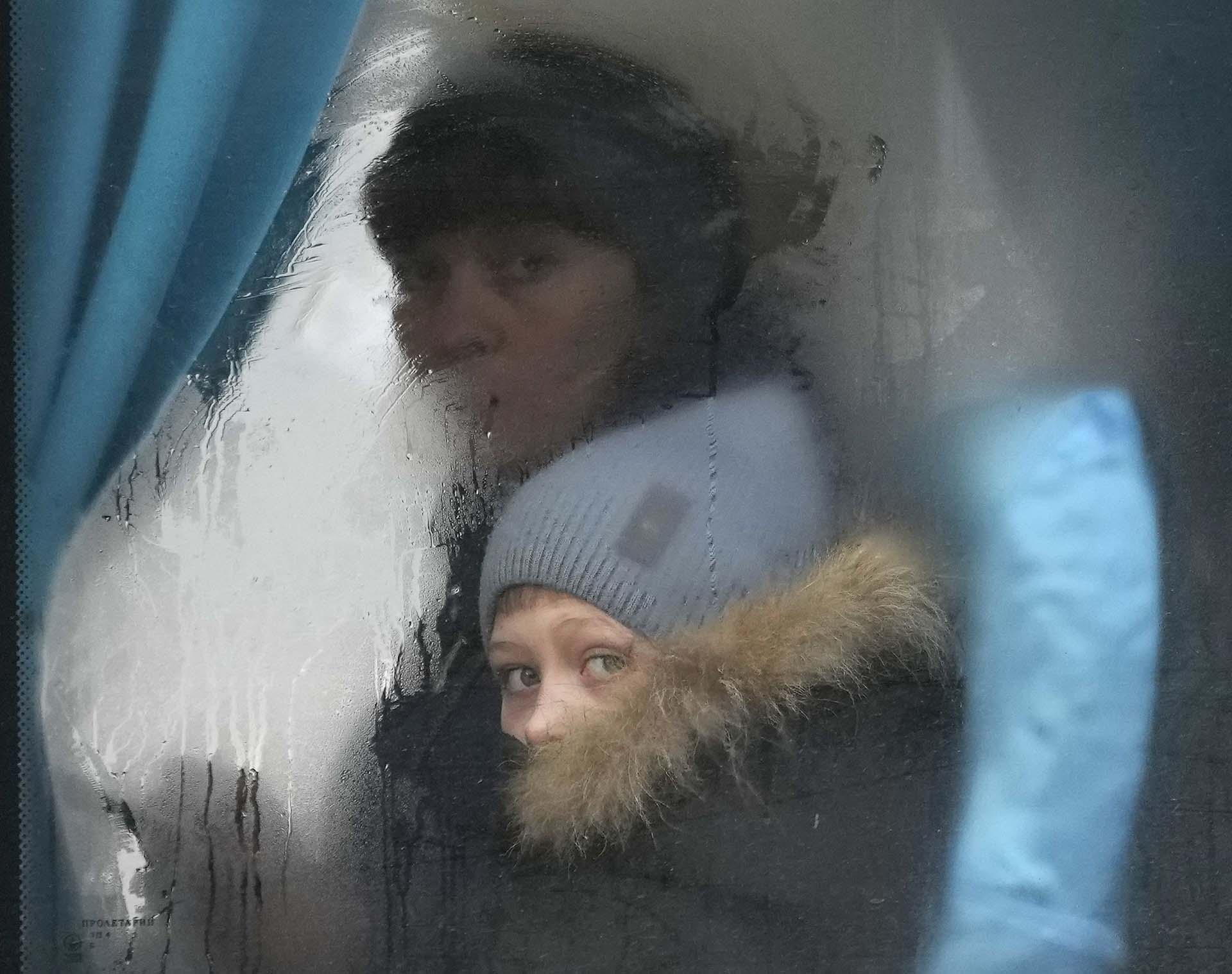 Una mujer y un niño miran por la ventana de un autobús cuando escapan de Sievierodonetsk, en la región de Luhansk, en el este de Ucrania.