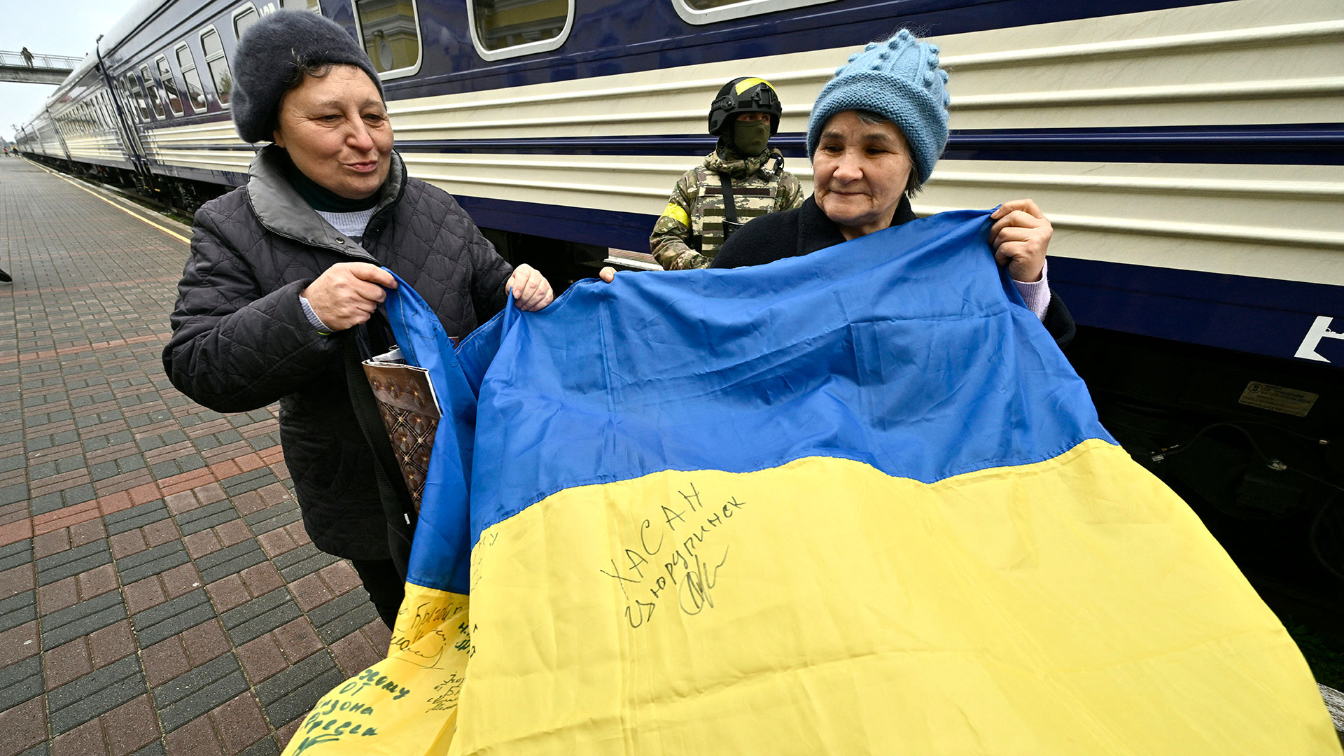 Two people hold a Ukrainian flag (GENYA SAVILOV/AFP)