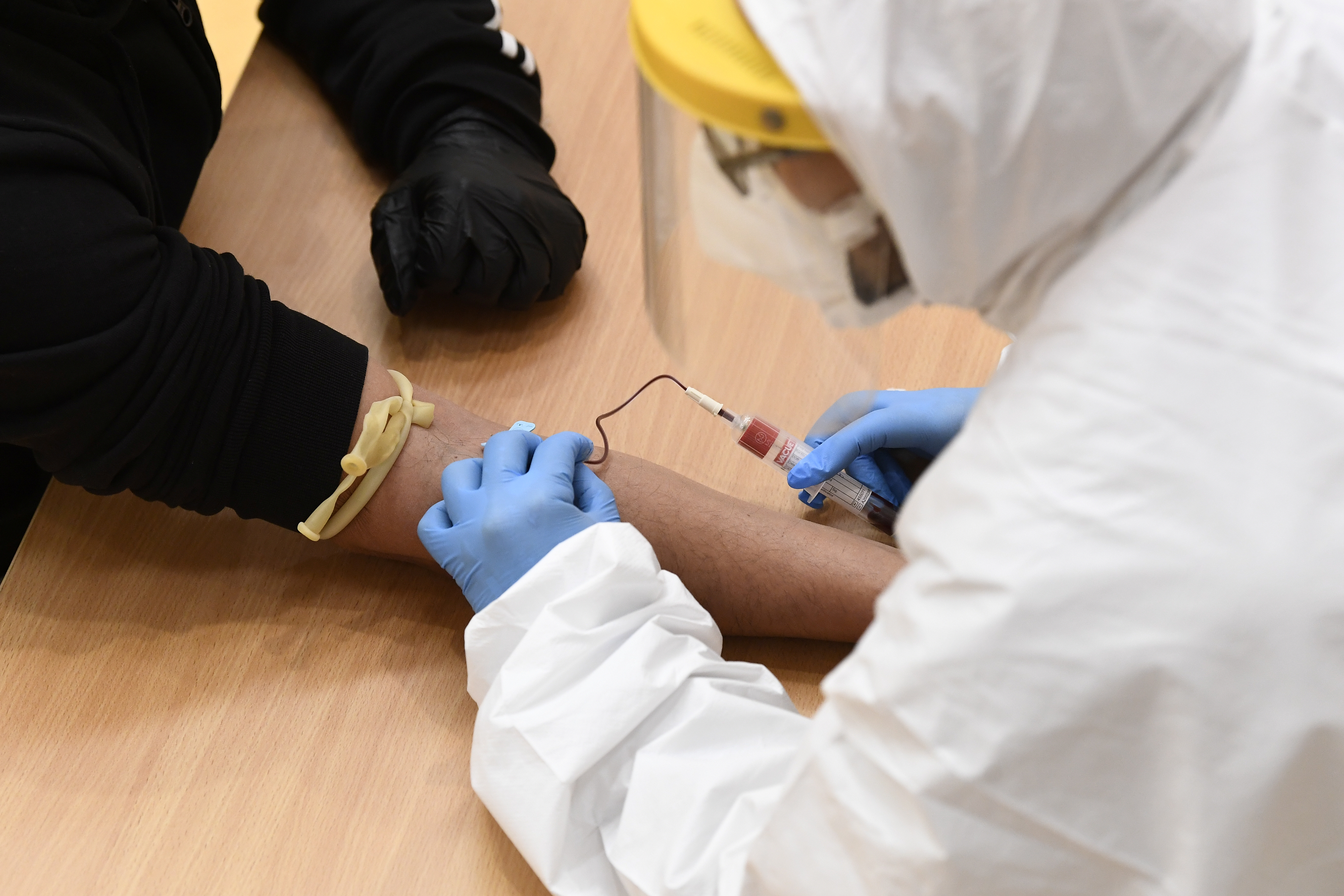 Un trabajador médico toma una muestra de sangre de un hombre para detectar la enfermedad del coronavirus (COVID-19) en Cisliano, cerca de Milán, Italia, el 21 de abril de 2020 [Fotografía tomada el 21 de abril de 2020] (Reuters/ Flavio Lo Scalzo)
