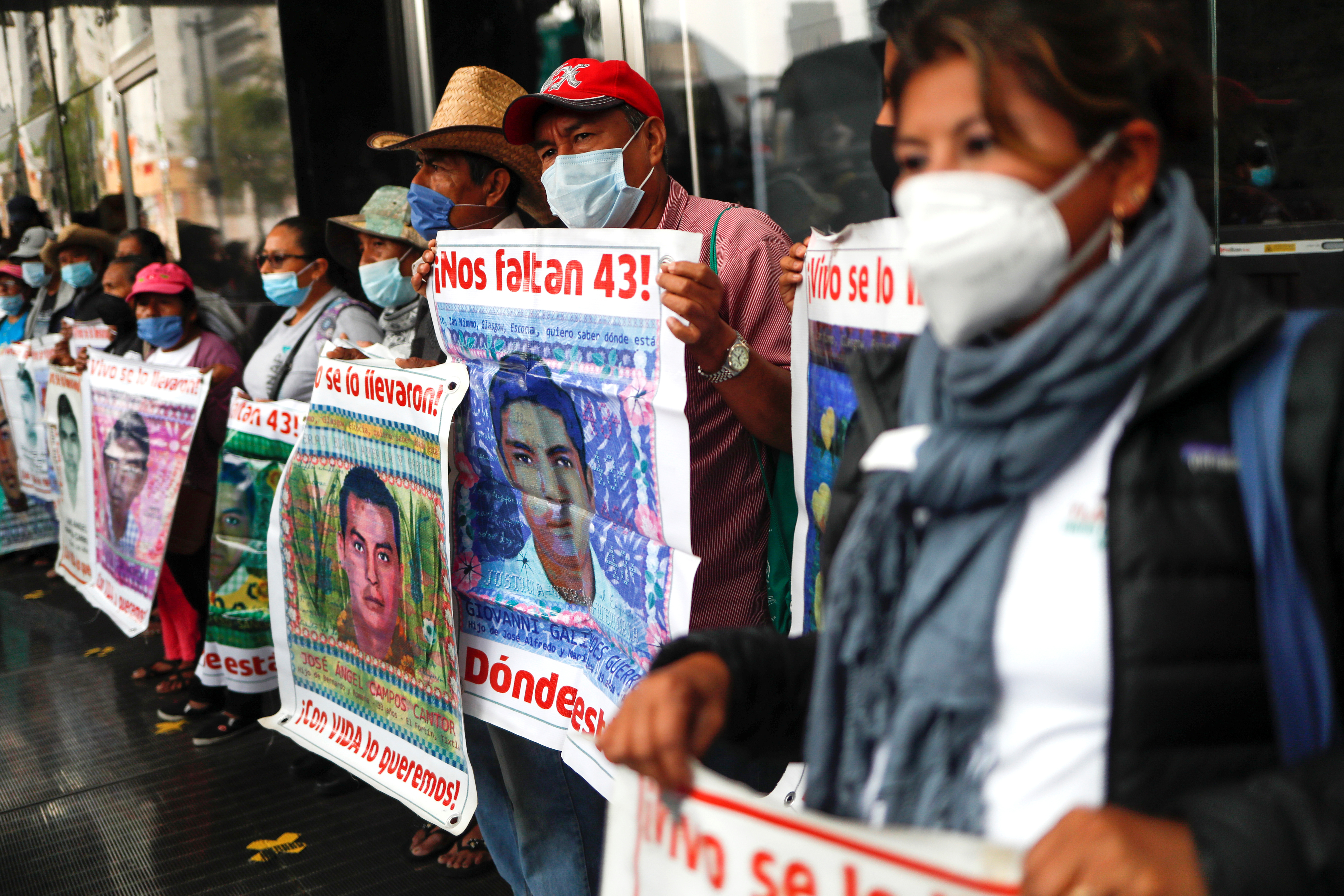 Familiares de estudiantes desaparecidos sostienen carteles con sus imágenes mientras participan en una protesta frente a la Fiscalía General de la República, antes del sexto aniversario de la desaparición de 43 estudiantes de la Escuela Normal Rural de Ayotzinapa, en la Ciudad de México, México 25 de septiembre de 2020.